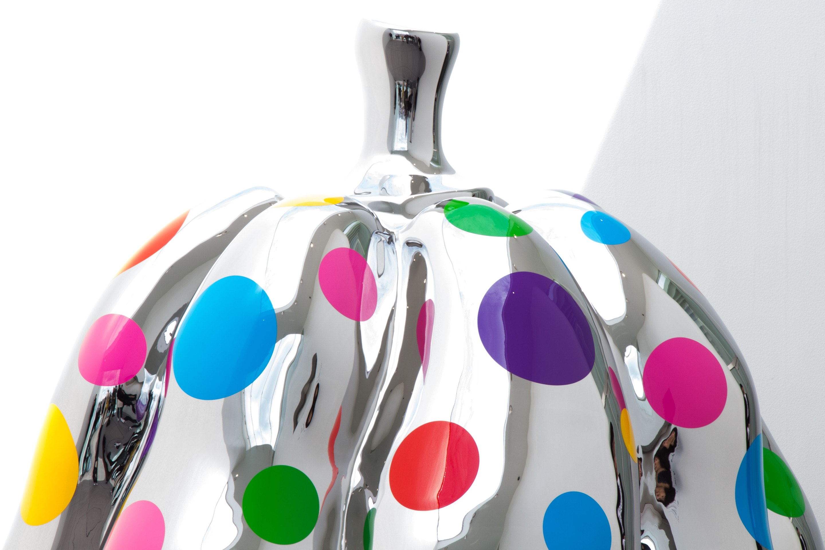 A sculpture by Yayoi Kusama — one of her polished chrome pumpkins with colourful dots in various sizes adorning the mirrored surface — at Kusamayayoi Museum in Tokyo, Japan