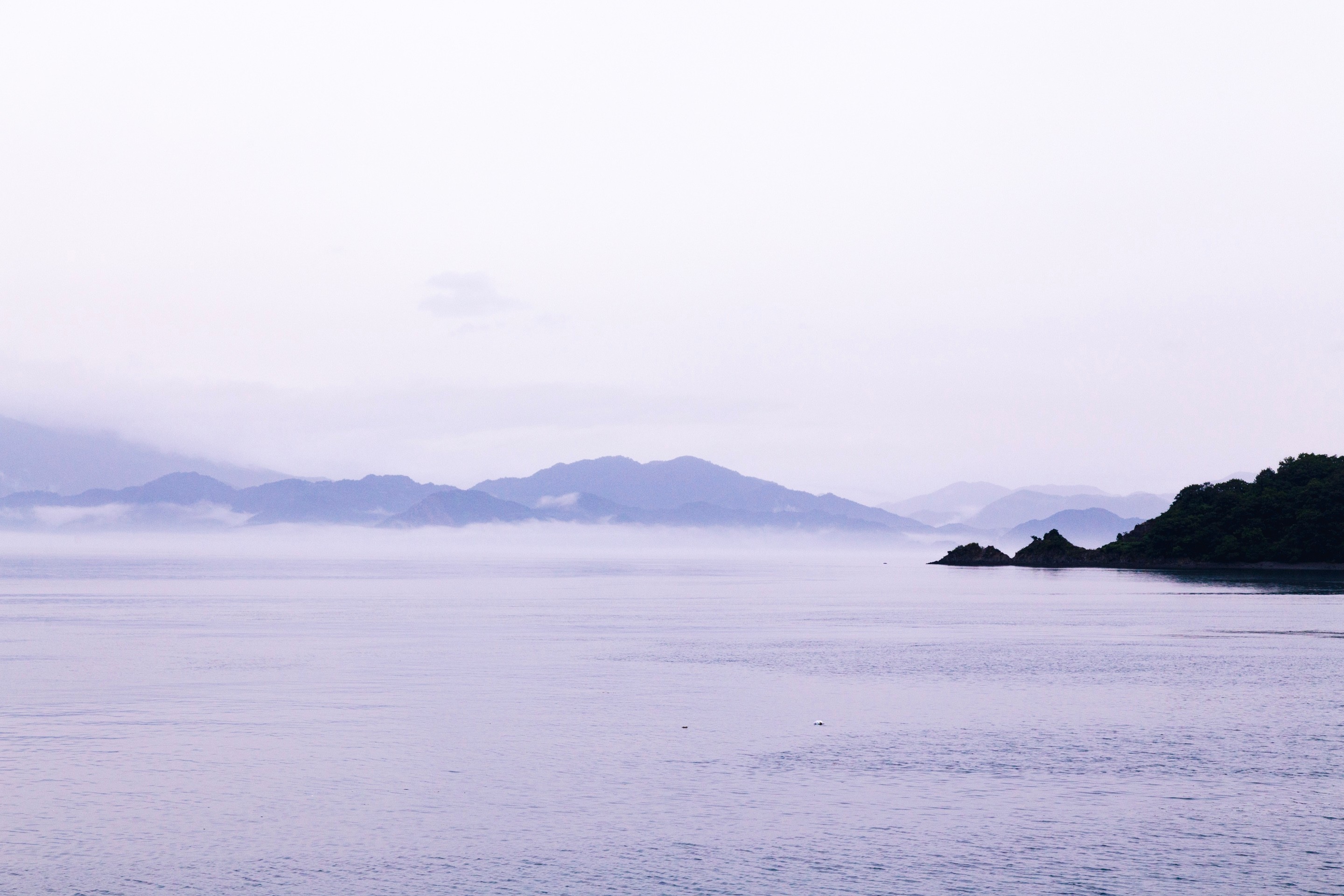 A lilac-washed seascape scene taken from Osaki Shimojima Island, looking out over veiled layers of mountainous islands — Geiyo Region, Hiroshima Prefecture.