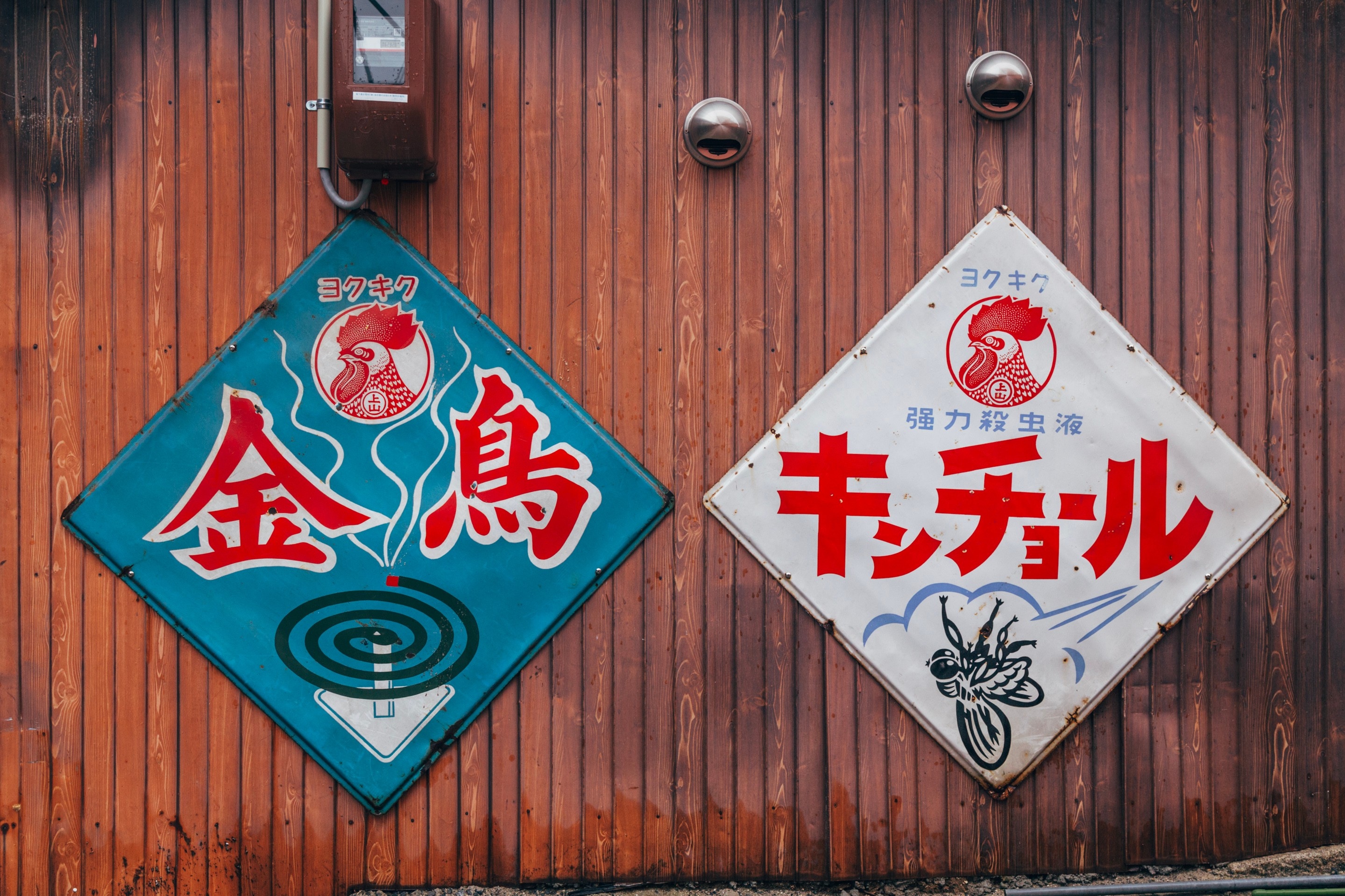 Large old metal signs nailed to the side of a wooded shop advertising insect repellant coils and insect killer spray — Mitarai village, Osaki Shimojima Island, Geiyo Region.