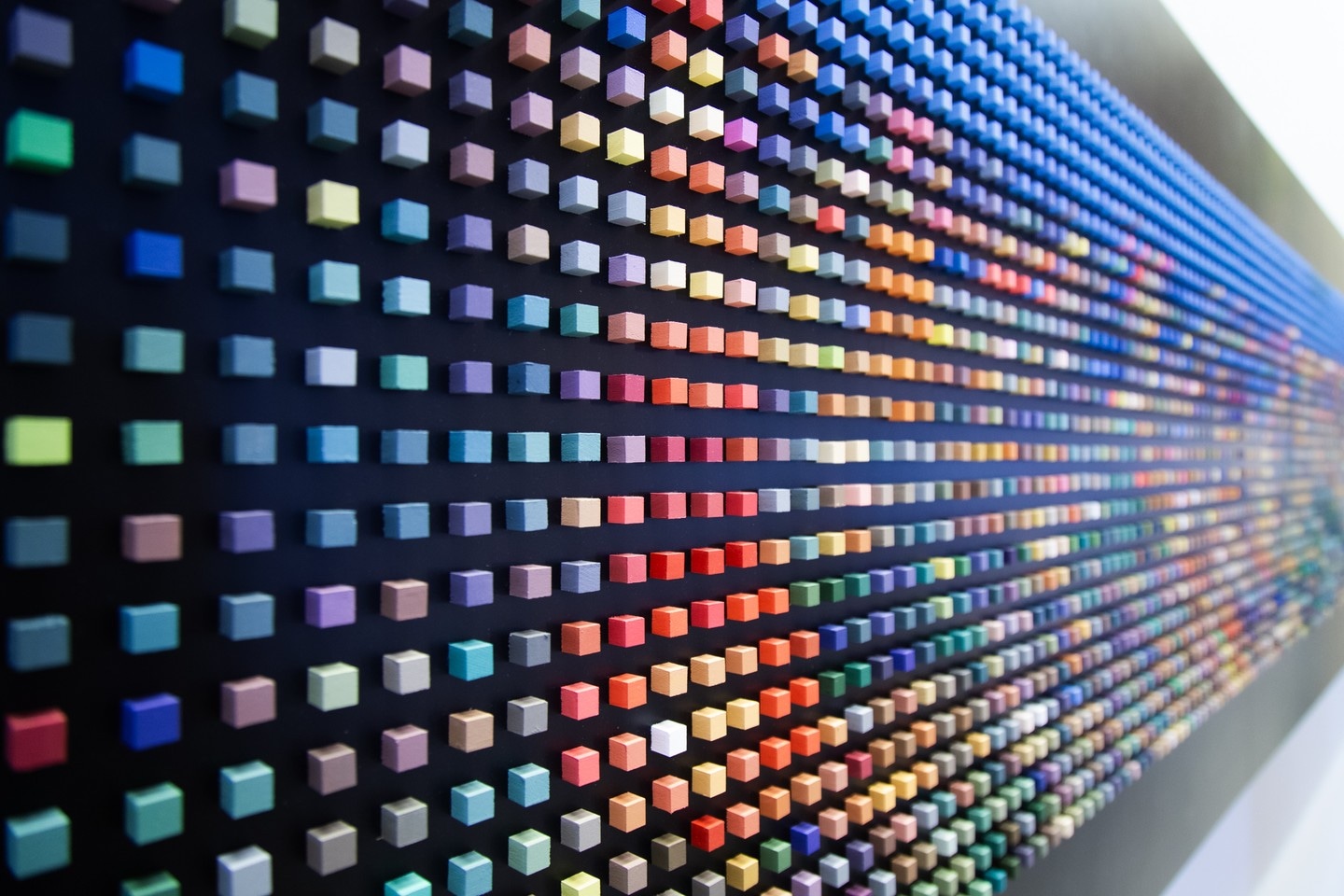 Small coloured cubes act as 'pixels' on a black background. Each pixel a point of light building a picture of the Tokyo cityscape at night. The perpective of the shot is strong. Tokyo, Japan.