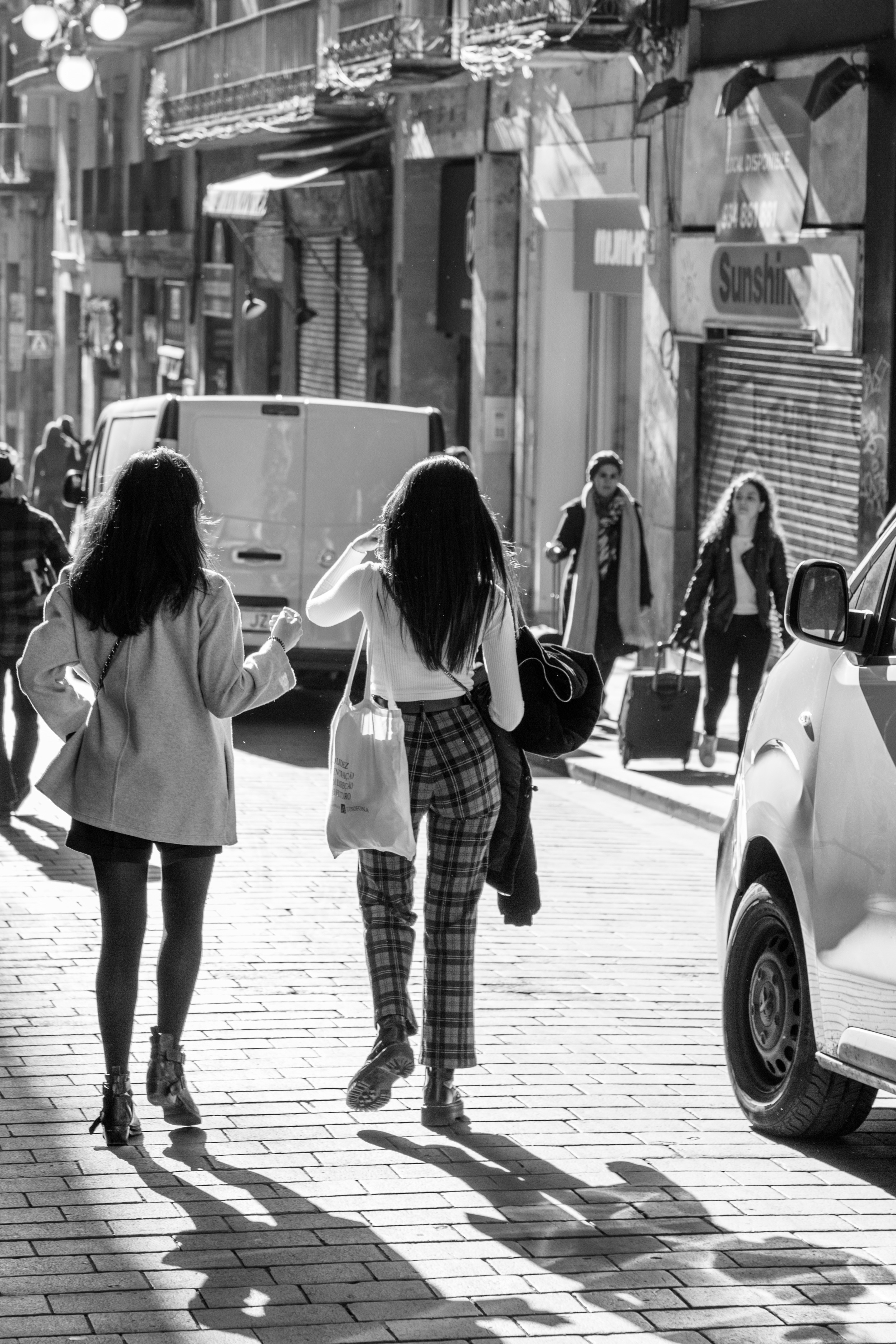 A couple of women walking down a busy street in Barcelona