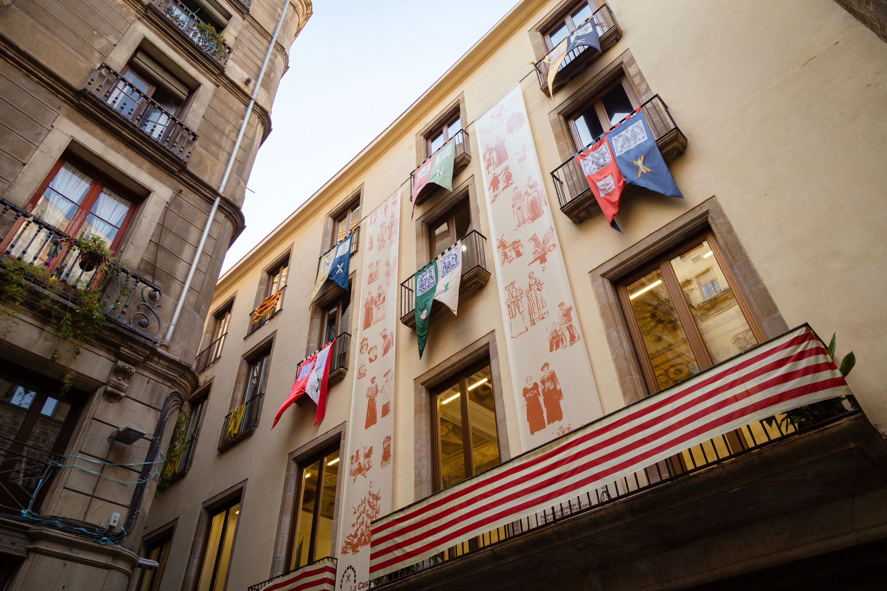 Only apartment building with colourful flags hanging of of the windows on the streets of Barcelona.