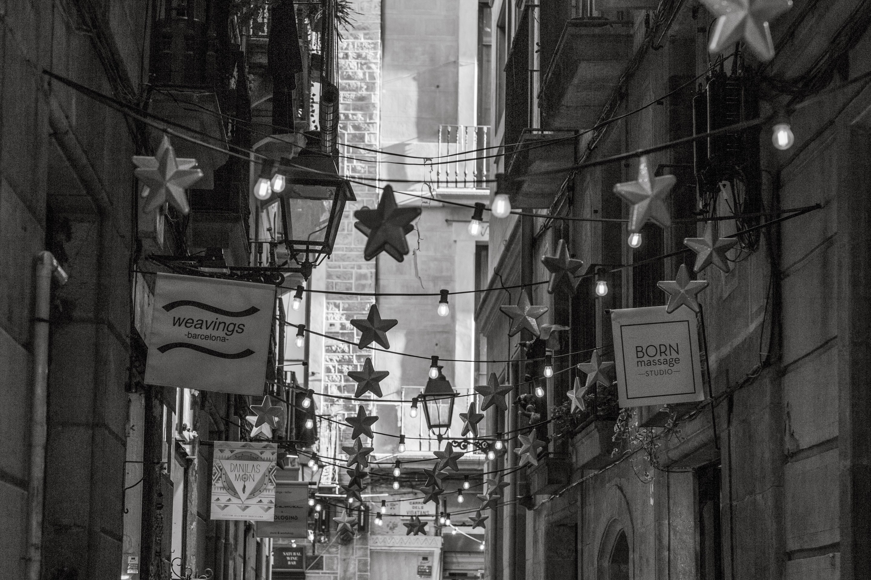 Strings of stars criss-crossing an old narrow street in Barcelona.
