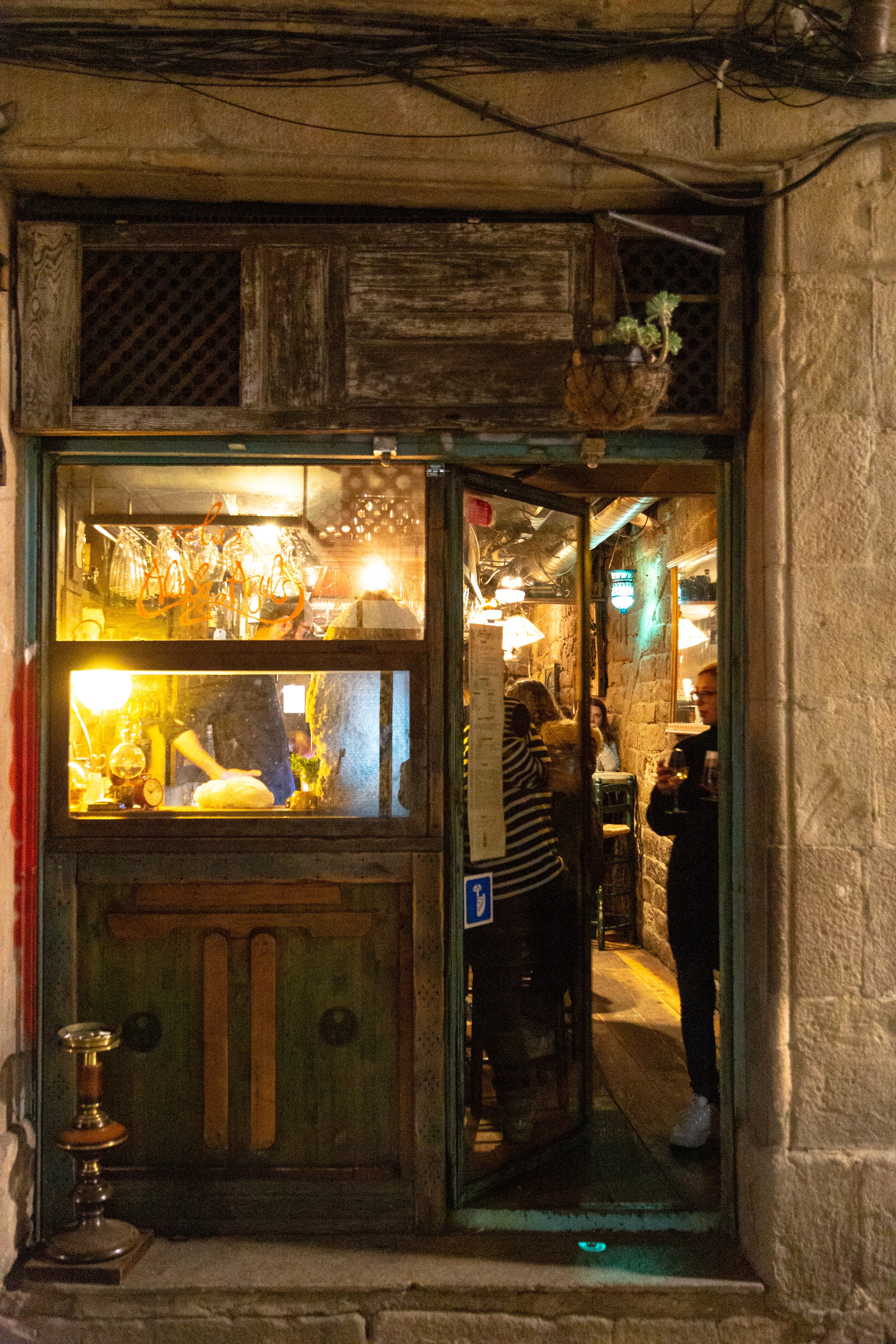 Entrance to an illuminated and inviting old bar in old Barcelona.