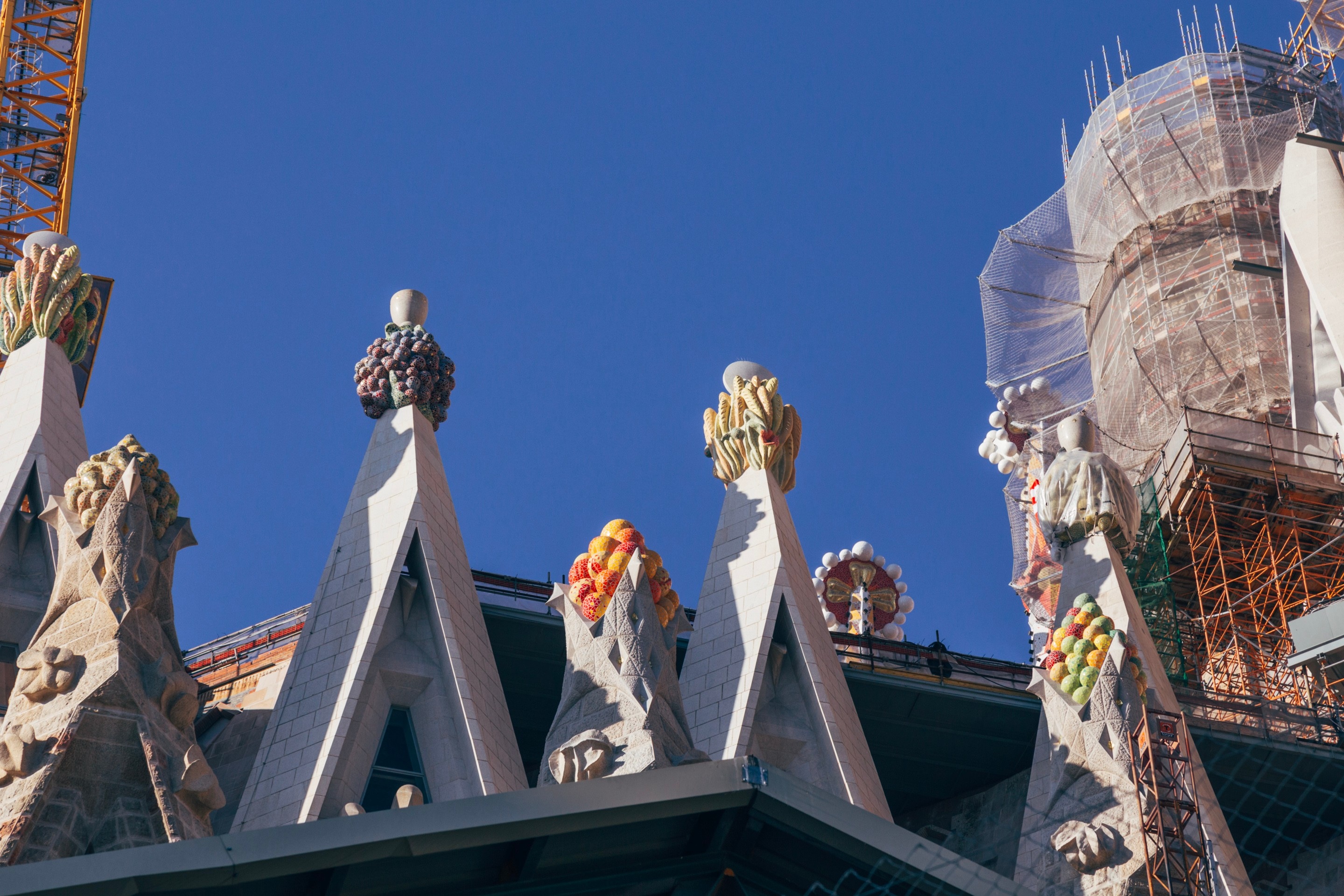 A close-up of some fruit sculptures atop small spires on La Sagrada Familia