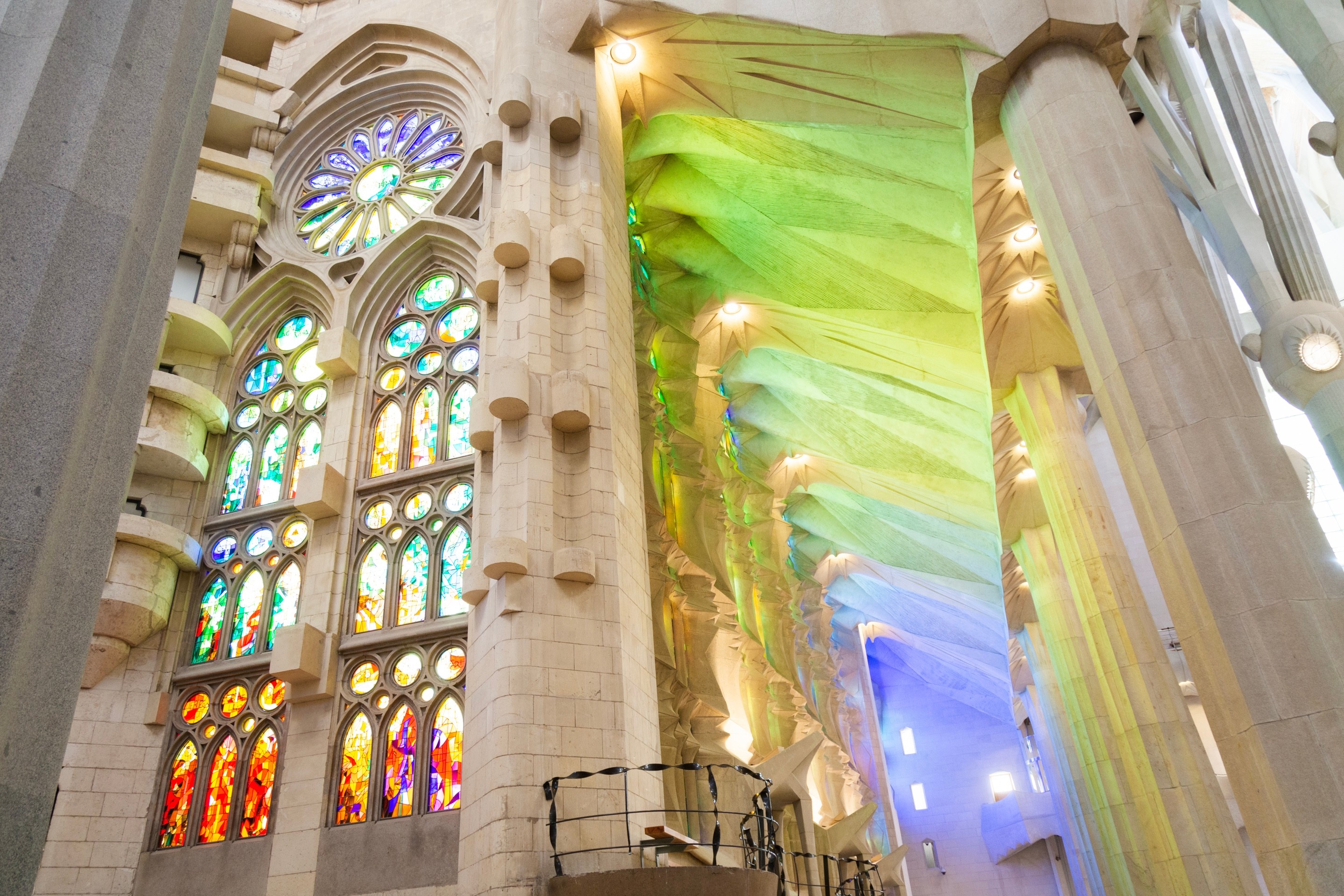 Beautiful colourful light streaming through the stained glass windows and illuminating the stone walls. La Sagrada Familia.