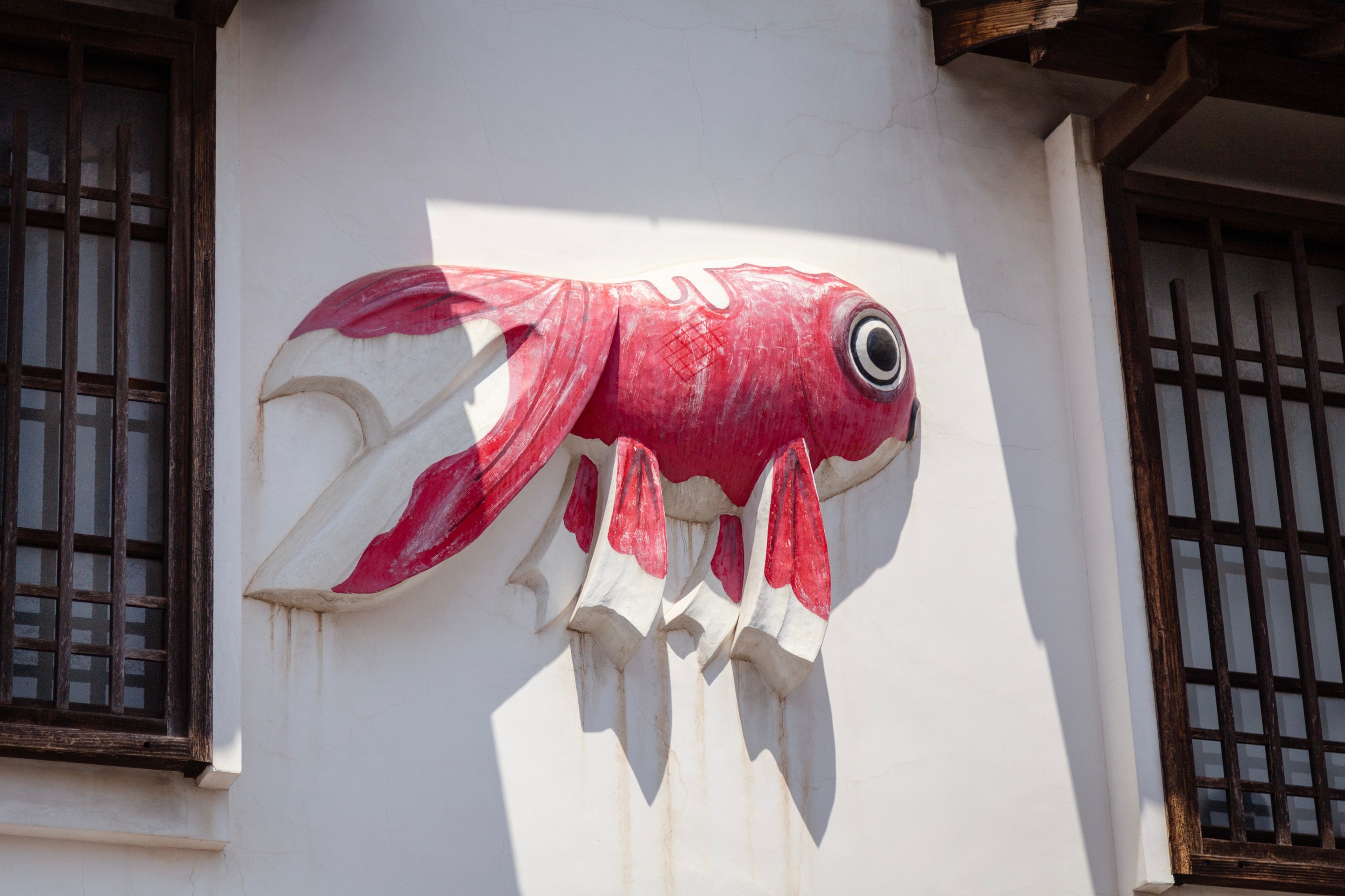 A large goldfish sculpture attached to the side of a shop building — Yanai, Yamaguchi Prefecture, Japan
