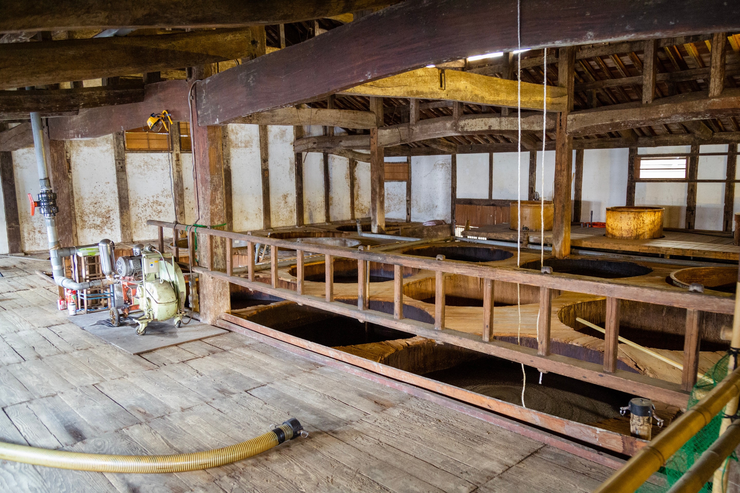 Large circular wooden vats containing fermenting soy sauce Kanro Joyu Soy Sauce Museum — Yanai, Yamaguchi Prefecture, Japan