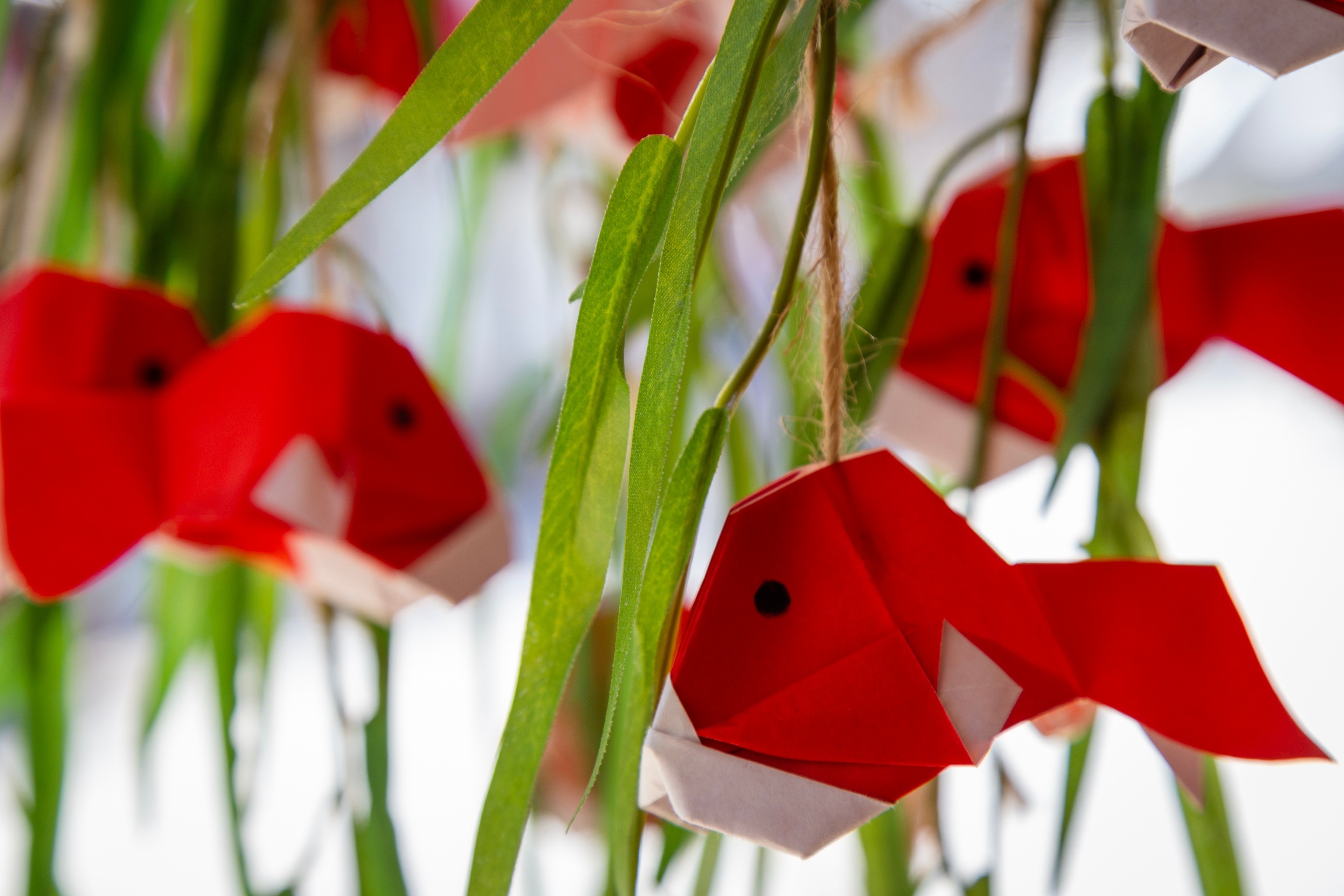 A synthetic plant's leave displaying four hanging origami goldfish — Yanai, Yamaguchi Prefecture, Japan