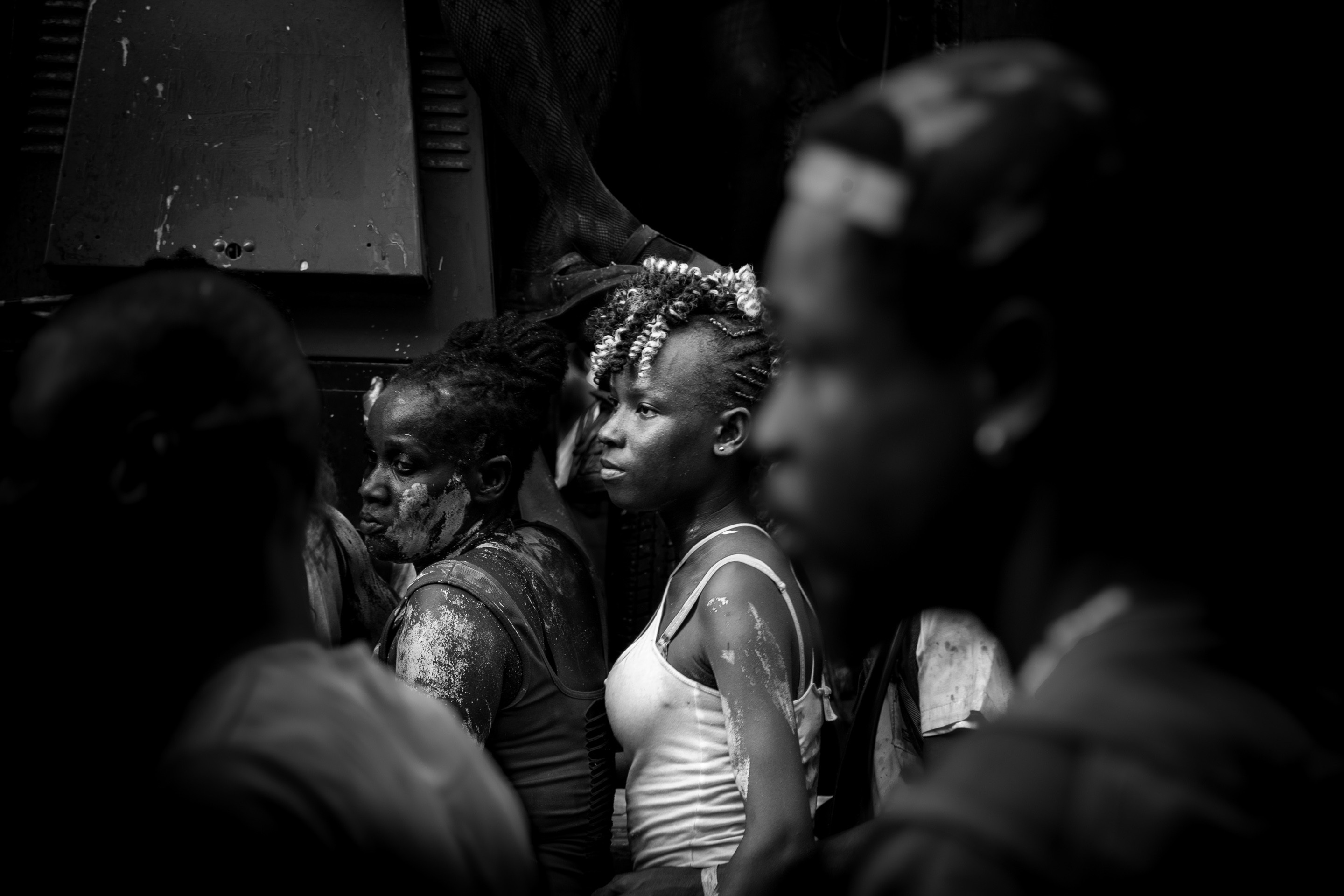 Black and white photo of exhausted party reveler covered in vibrant paints. Taken at Vincy Mas, the annual carnival in St. Vincent— Kingstown, Saint Vincent and the Grenadines