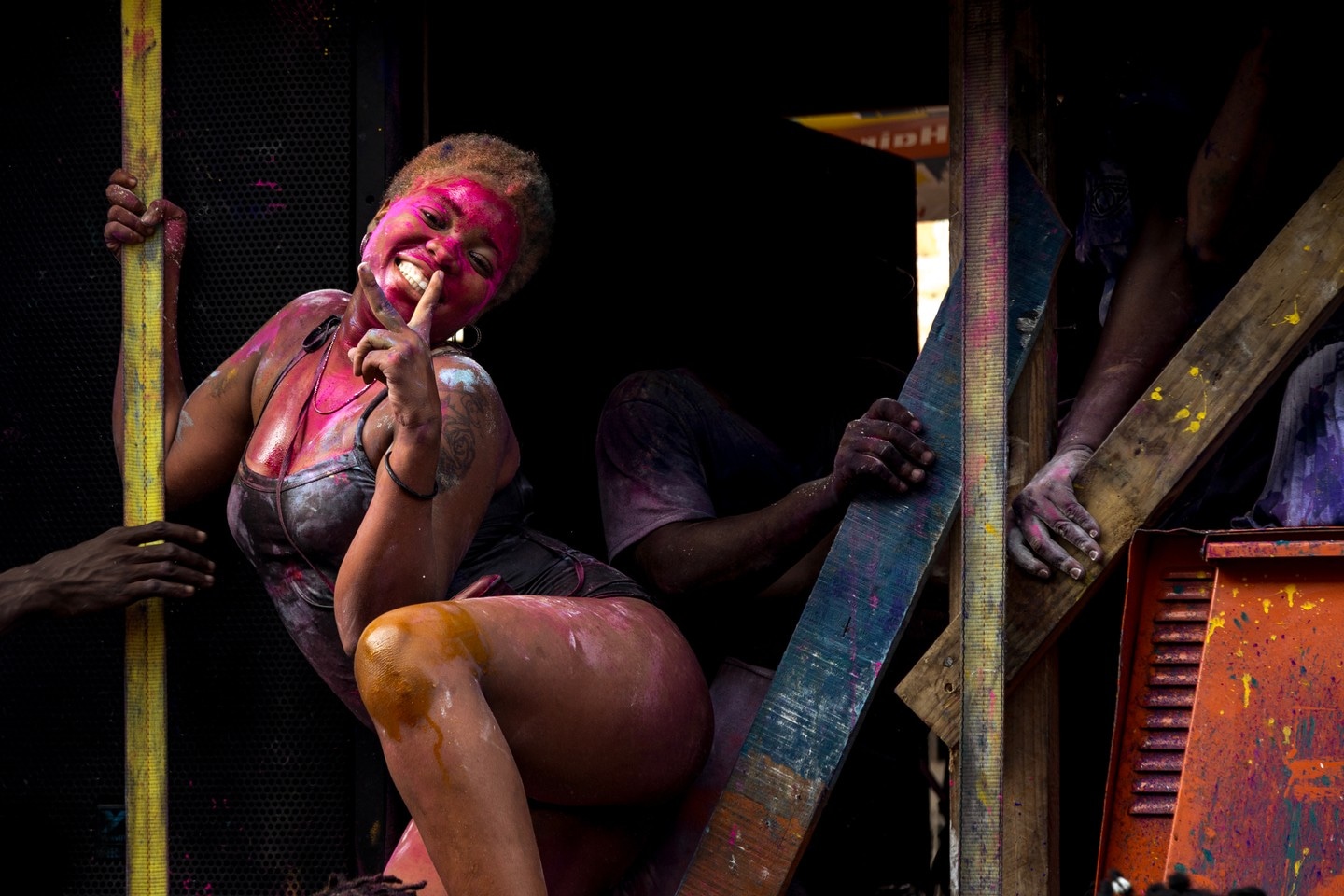 Party reveler, covered in vibrant paints, poses for the camera whilst she rides on a float to celebrate Vincy Mas, the annual carnival — Kingstown, Saint Vincent and the Grenadines