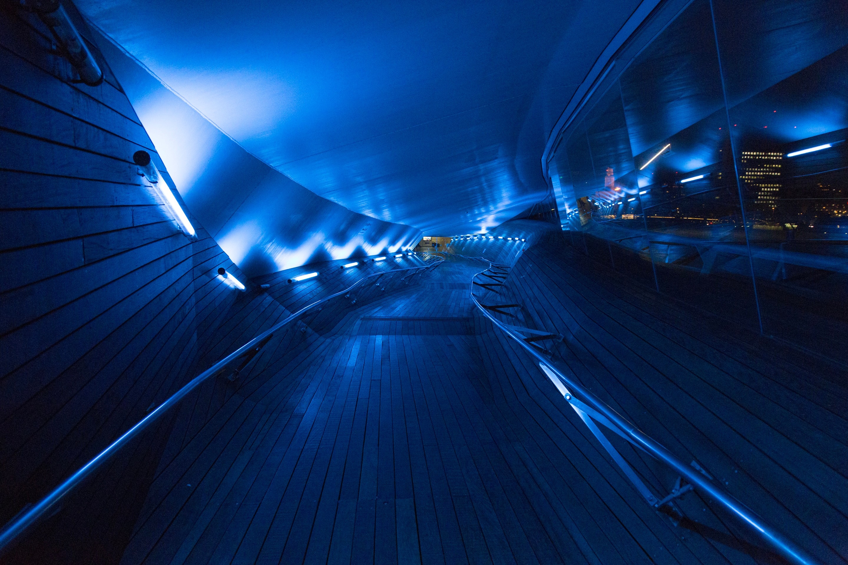 Surreal blue lights lead the eye down the architectural passenger tunnel at the Ōsanbashi Pier, the main international passenger pier — Port of Yokohama, Japan