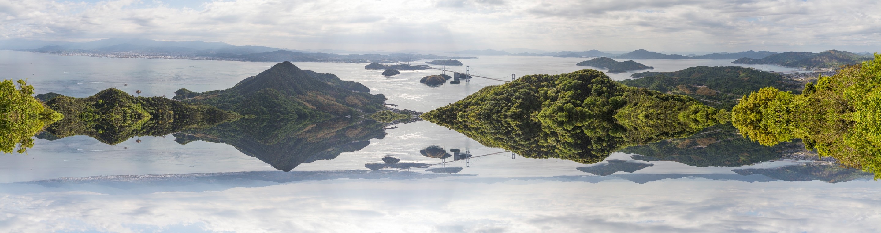 A wide, mirrored on the x-axis, panorama of the Kurushima Kaikyo Bridge and surrounding mountainous islands  — Geiyo Region, Hiroshima Prefecture.