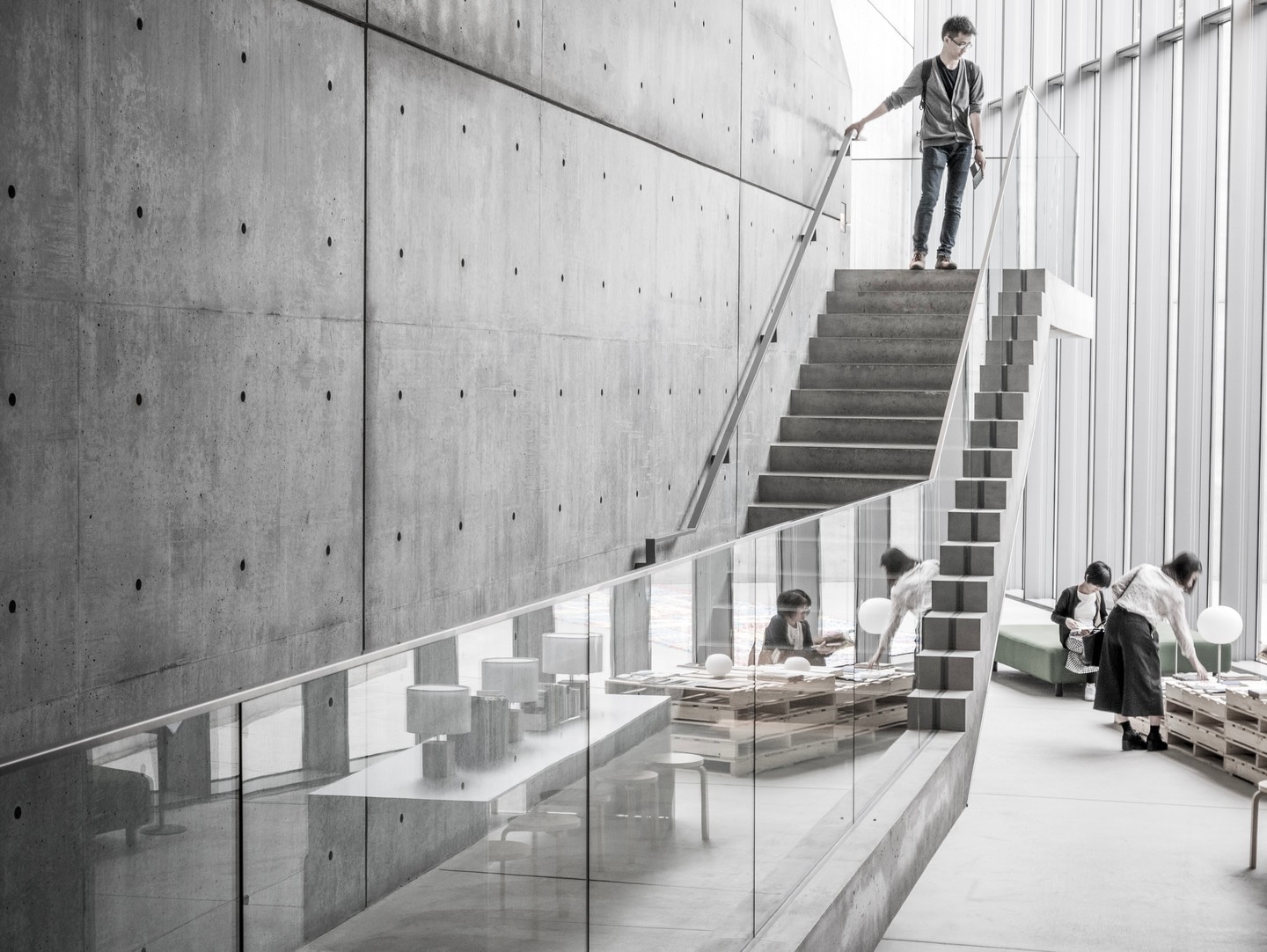 A gallery visitor stands at the top of the entrance stairs within the 21_21 Design Sight Gallery — Roppongi, Tokyo, Japan.