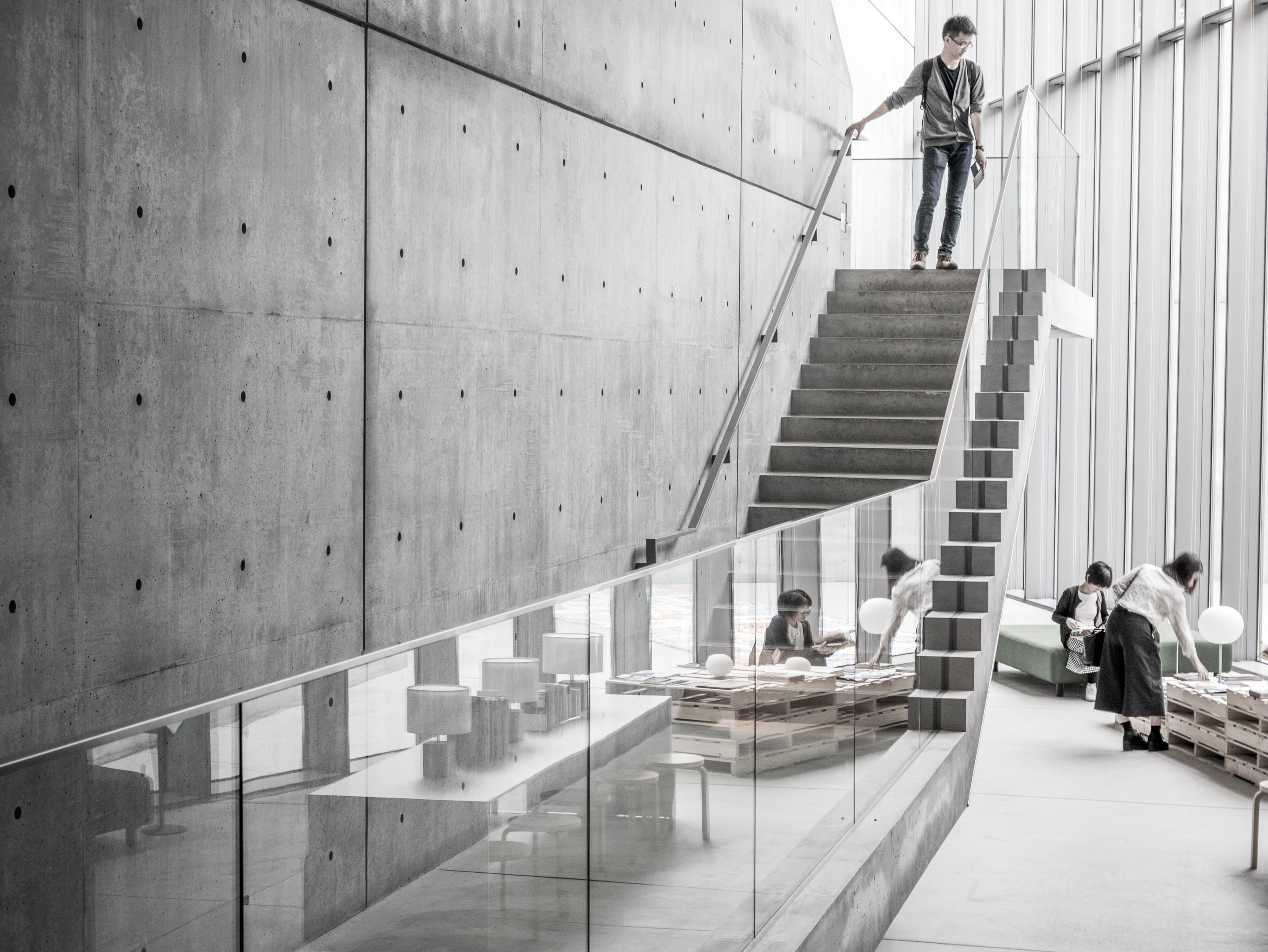 A gallery visitor stands at the top of the entrance stairs within the 21_21 Design Sight Gallery — Roppongi, Tokyo, Japan.