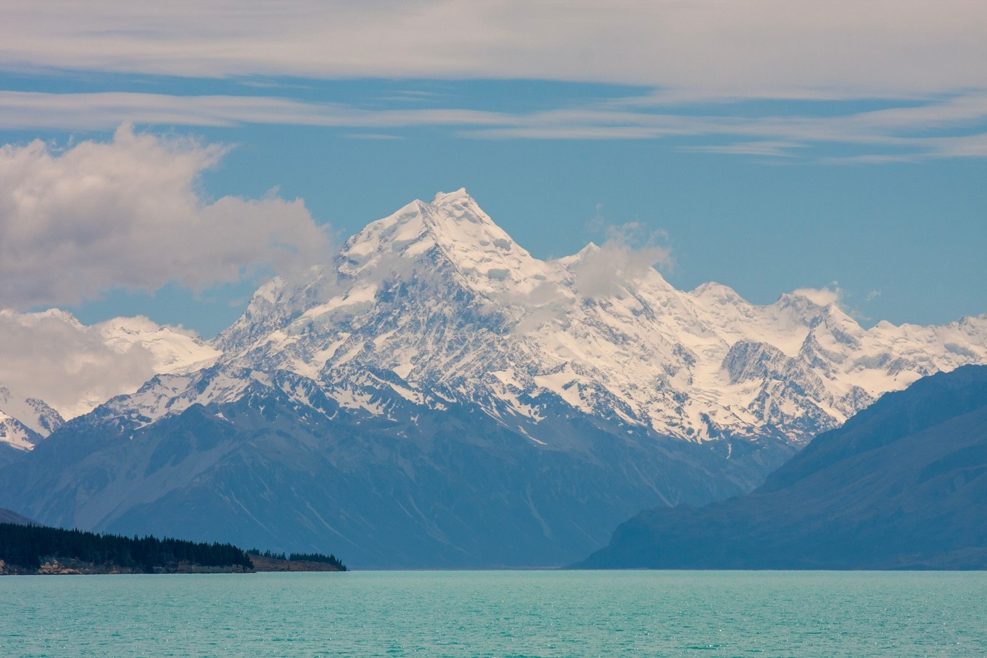 Mount Aoraki (Mt. Cook) rises majestically in the background, with the surreal teal blue waters of Lake Tekapo in the foreground — Southern Alps, South Island, New Zealand.