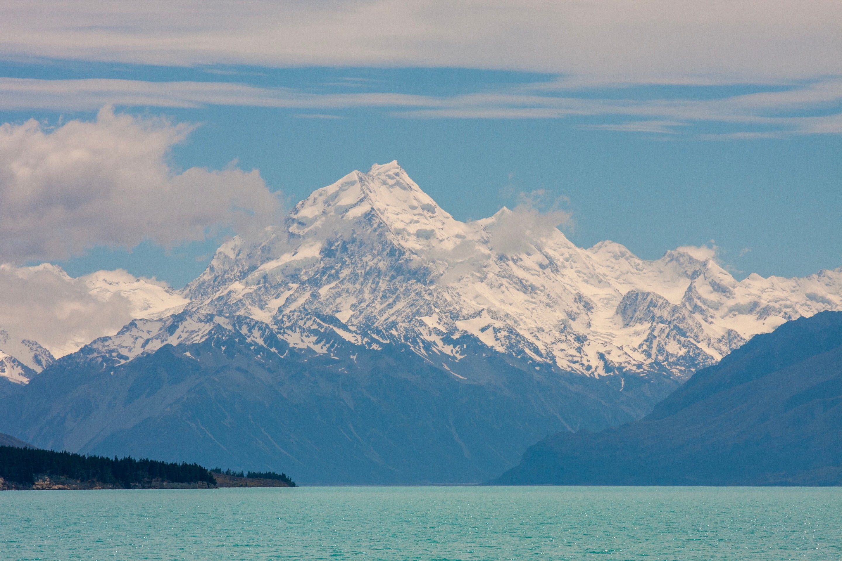 Mount Aoraki (Mt. Cook) rises majestically in the background, with the surreal teal blue waters of Lake Tekapo in the foreground — Southern Alps, South Island, New Zealand.