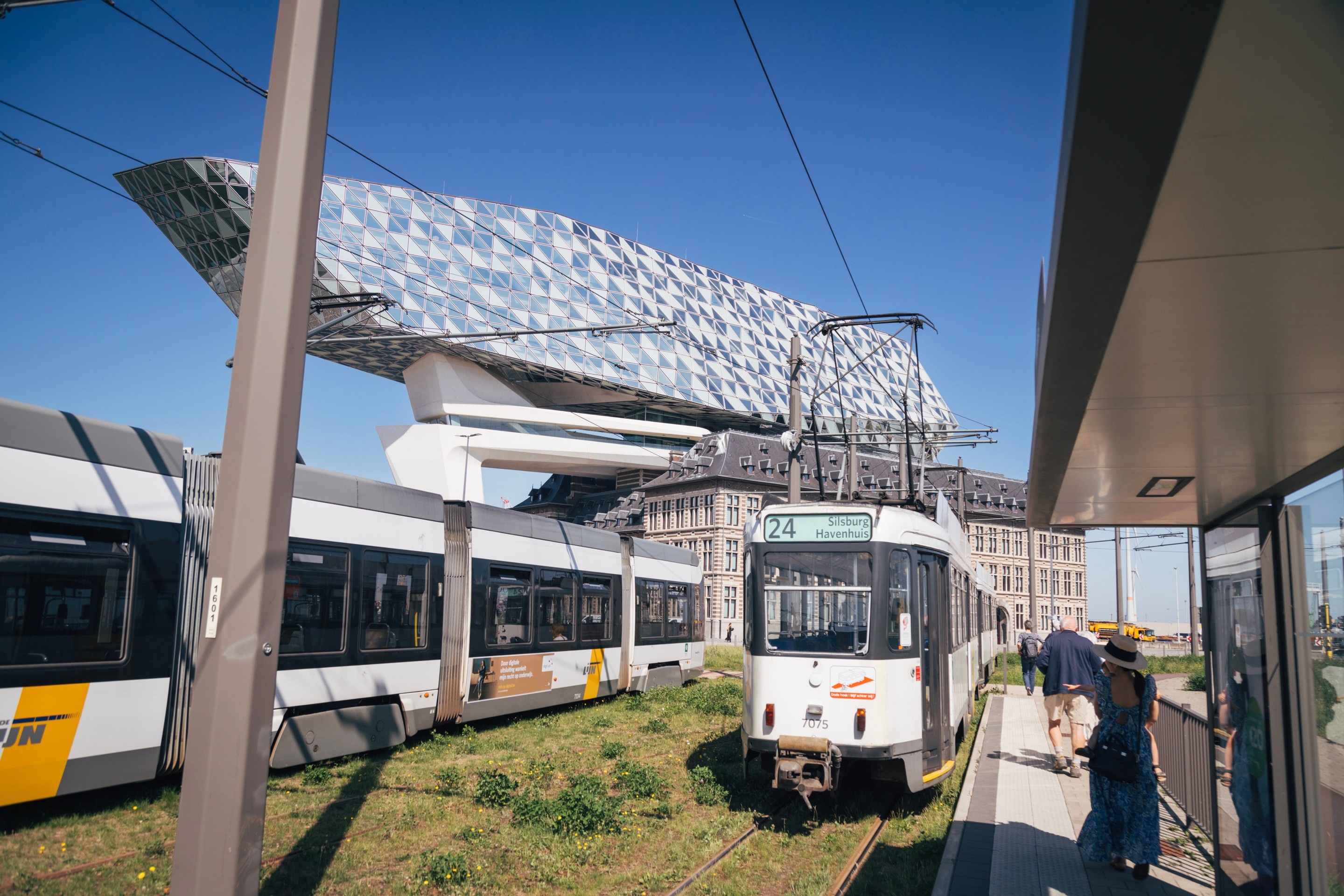 An open air tram station at the end of the line. In the background The Port House by Zaha Hadid can be seen — Antwerp, Belgium