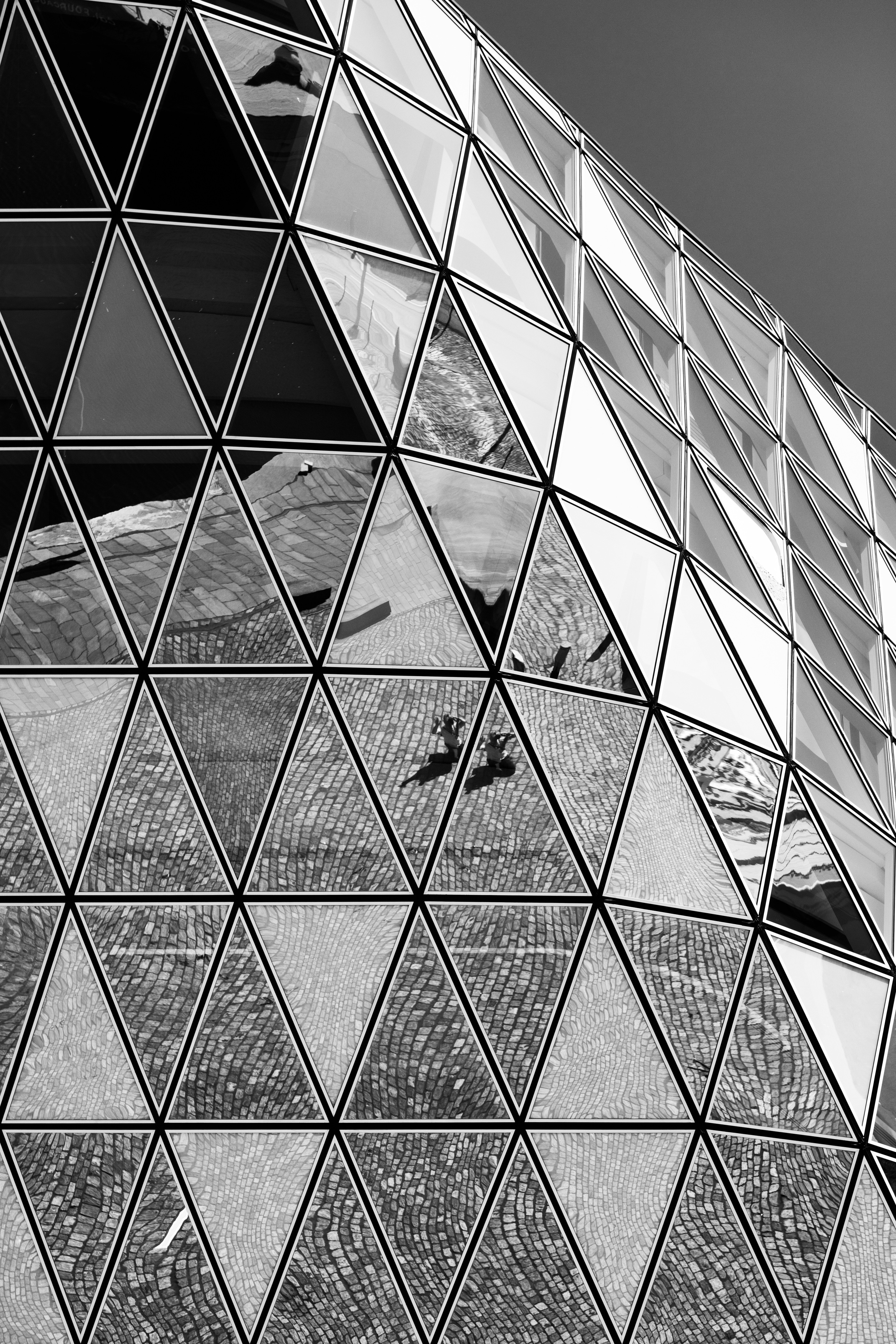Monochrome high contrast detail shot of the reflections that appear on the glass panels on the Port House by Zaha Hadid — Antwerp, Belgium