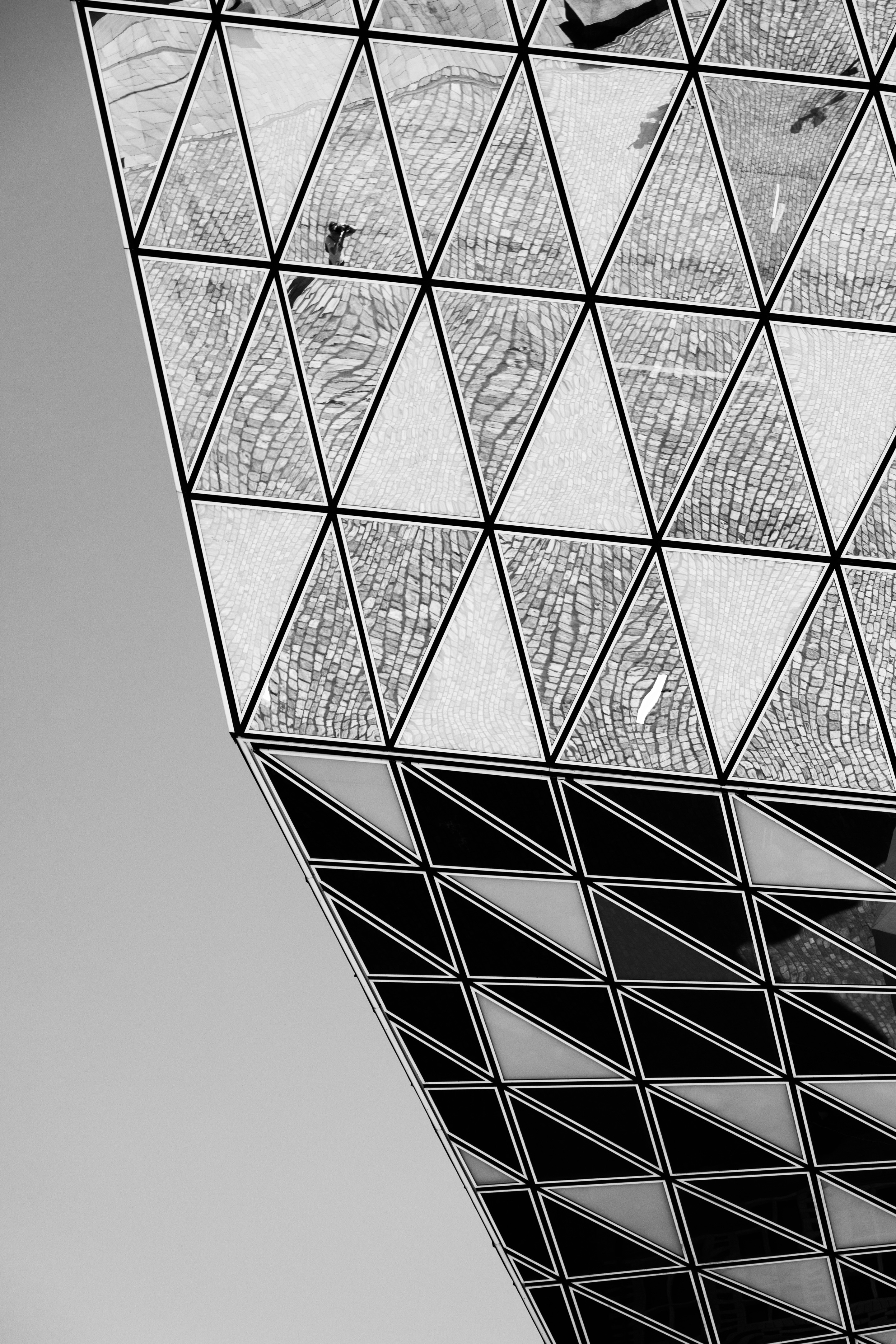 Monochrome high contrast detail shot of the reflections that appear on the glass panels on the Port House by Zaha Hadid — Antwerp, Belgium