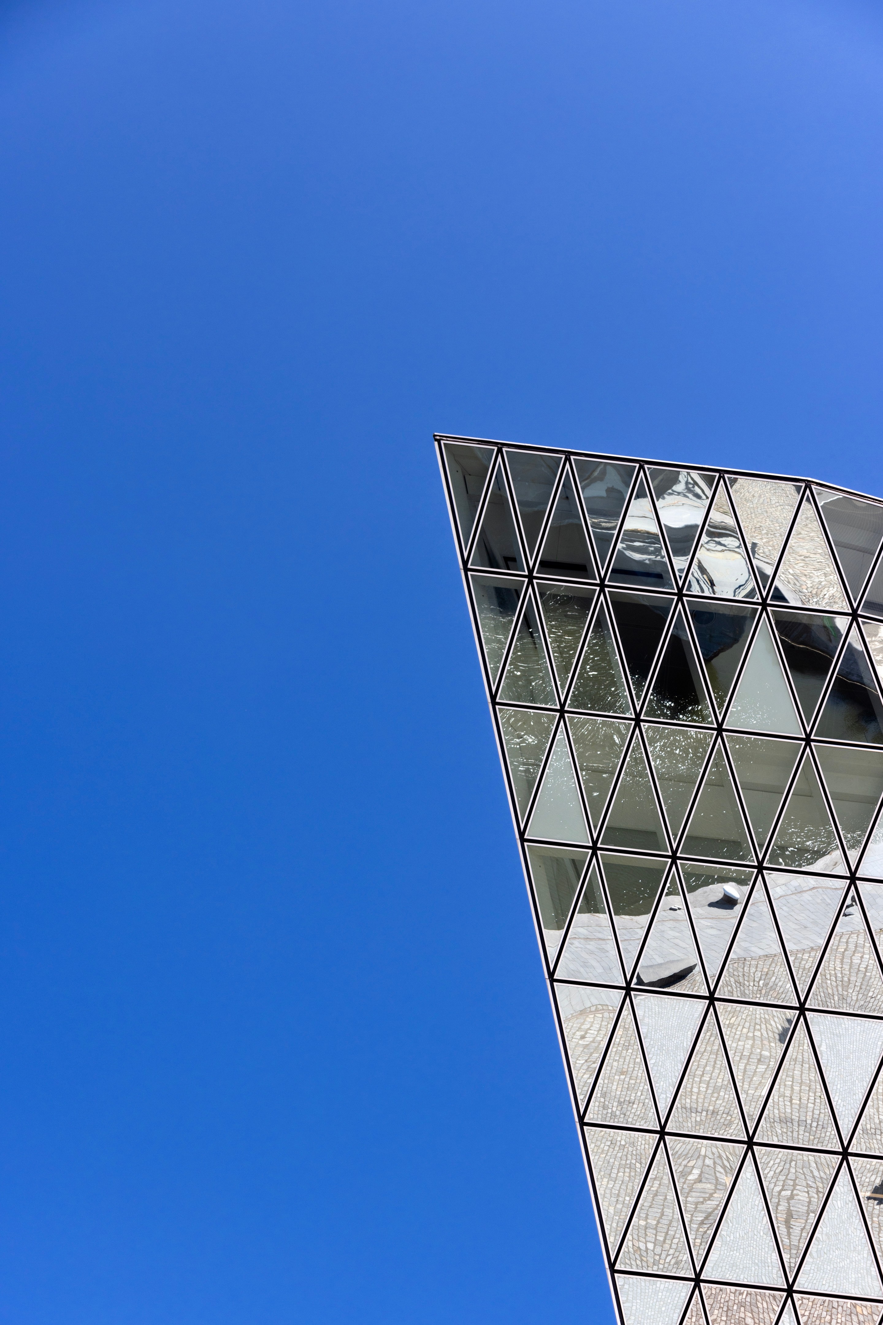 A close-up shot of a sharp corner from the glass extension on the Port House by Zaha Hadid — Antwerp, Belgium