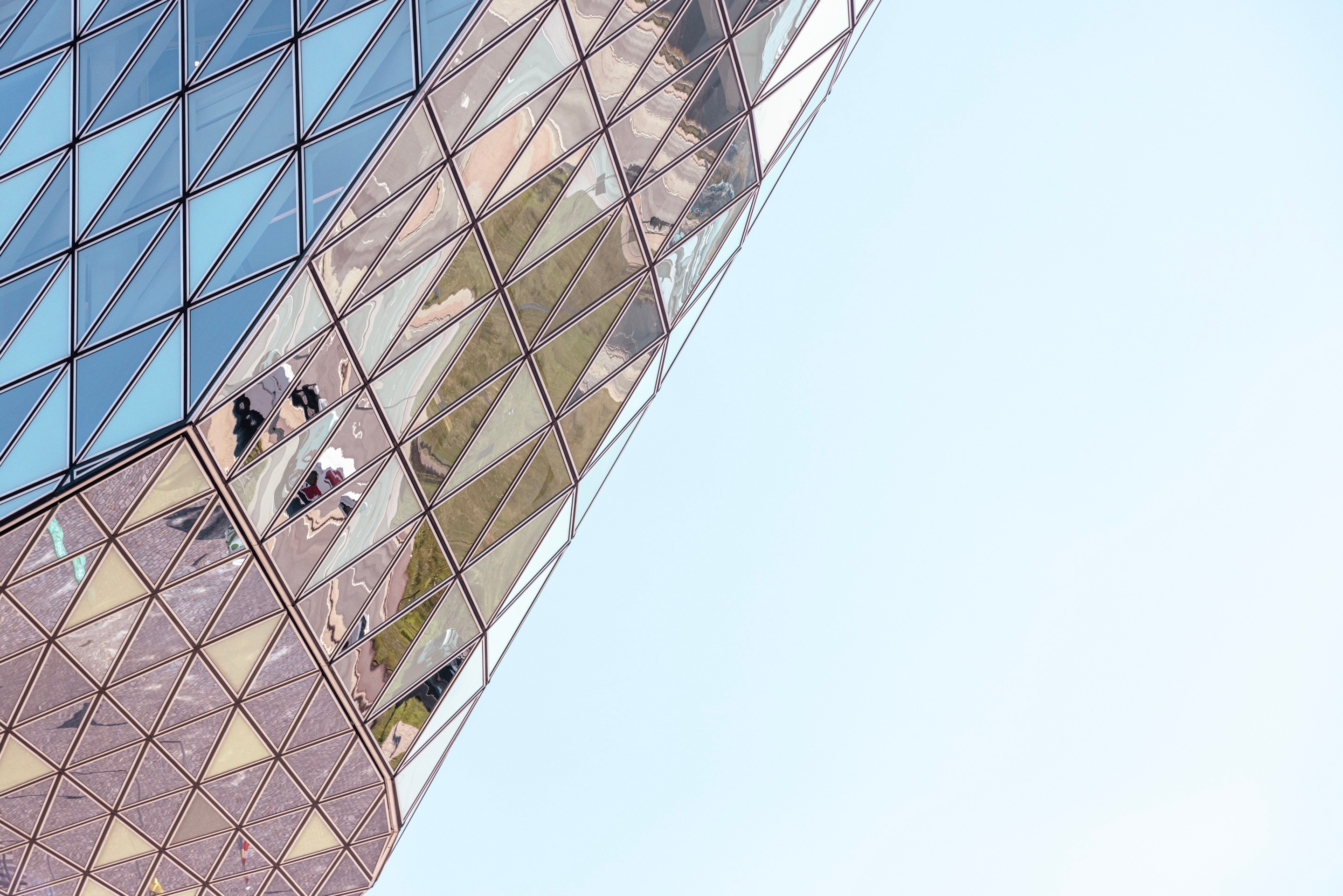 Colourful reflections that appear on the glass panels on the Port House by Zaha Hadid — Antwerp, Belgium