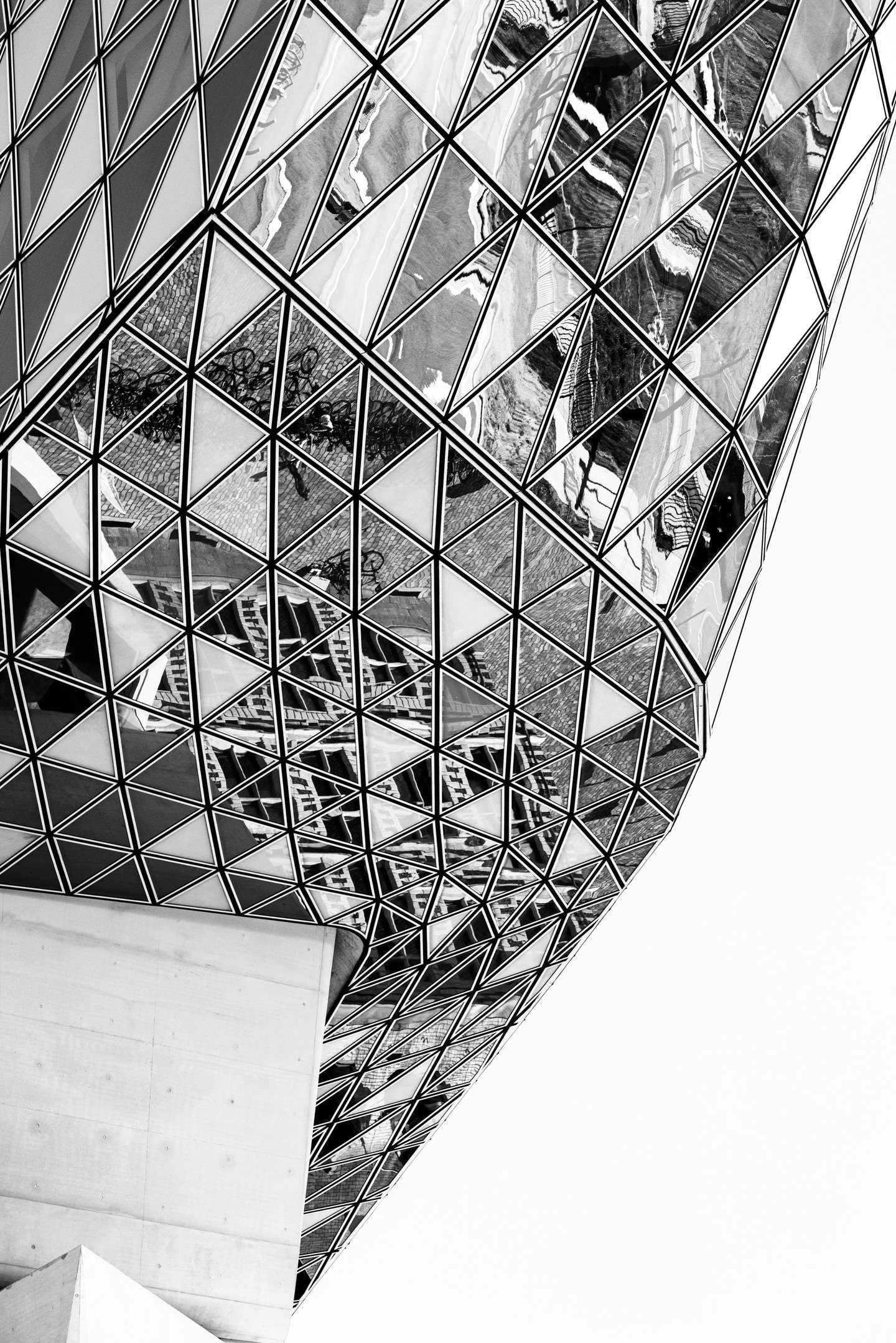 Monochrome high contrast detail shot of the reflections that appear on the glass panels on the Port House by Zaha Hadid — Antwerp, Belgium