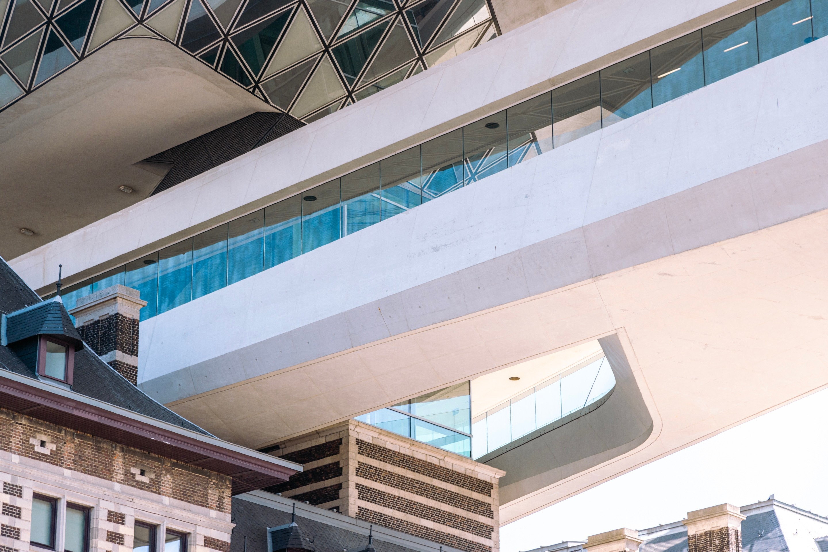 The cantilevered concrete support column meets the old brick construction of the firestation on The Port House by Zaha Hadid — Antwerp, Belgium 