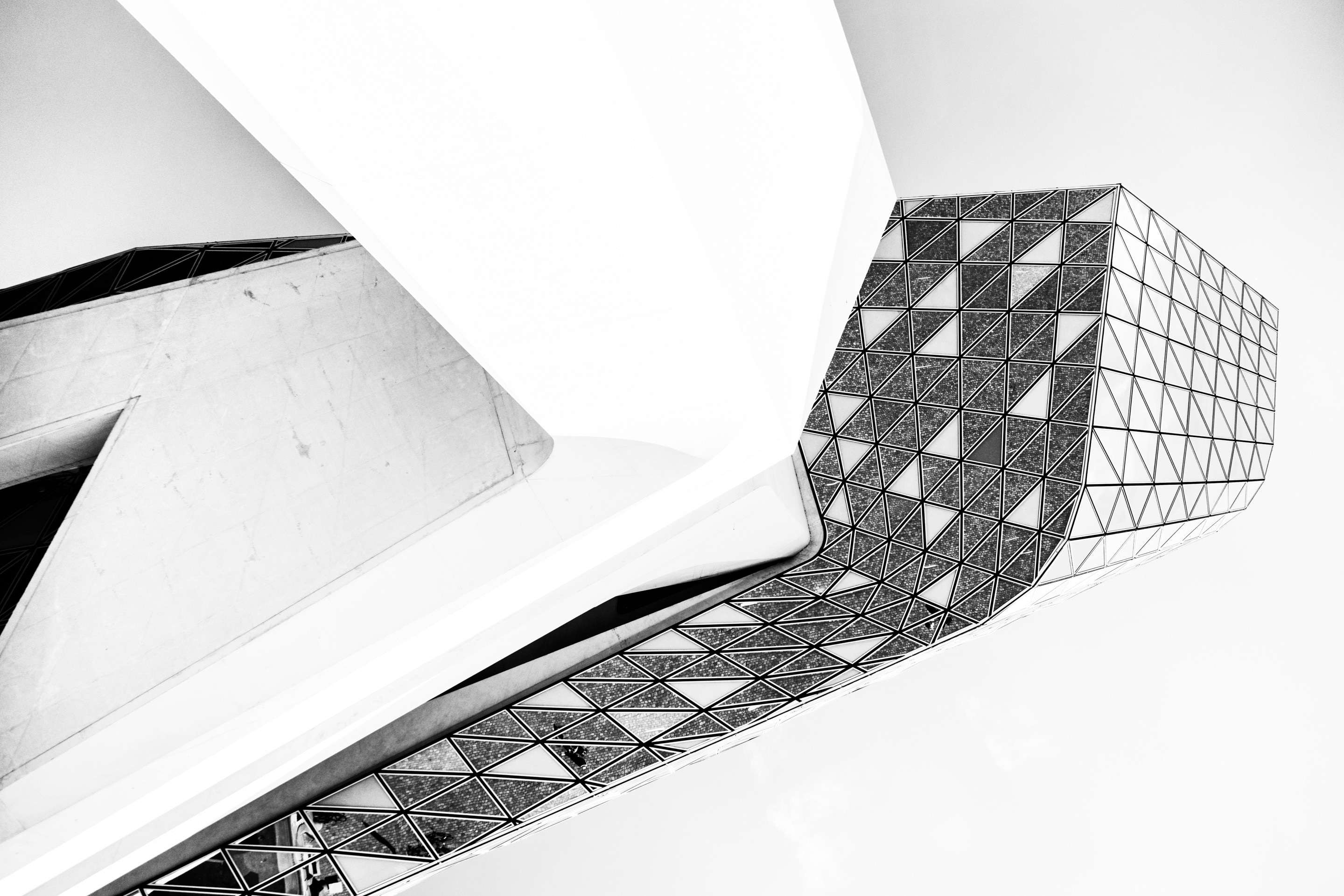 Looking up at the belly of the glass extension with the imposing concrete support column leading the eye up on The Port House by Zaha Hadid — Antwerp, Belgium 