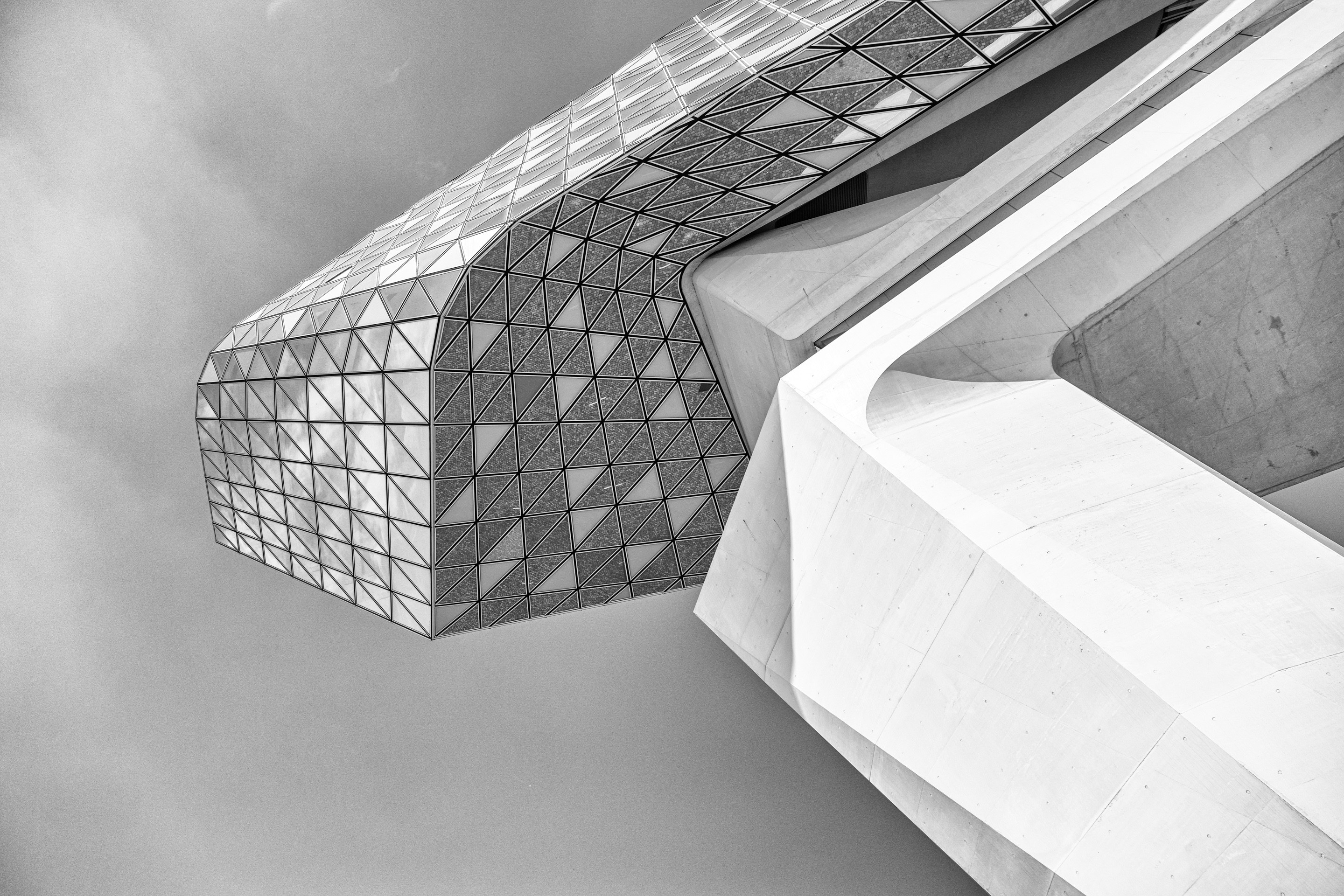 Looking up at the belly of the glass extension with the imposing concrete support column leading the eye up on The Port House by Zaha Hadid — Antwerp, Belgium 