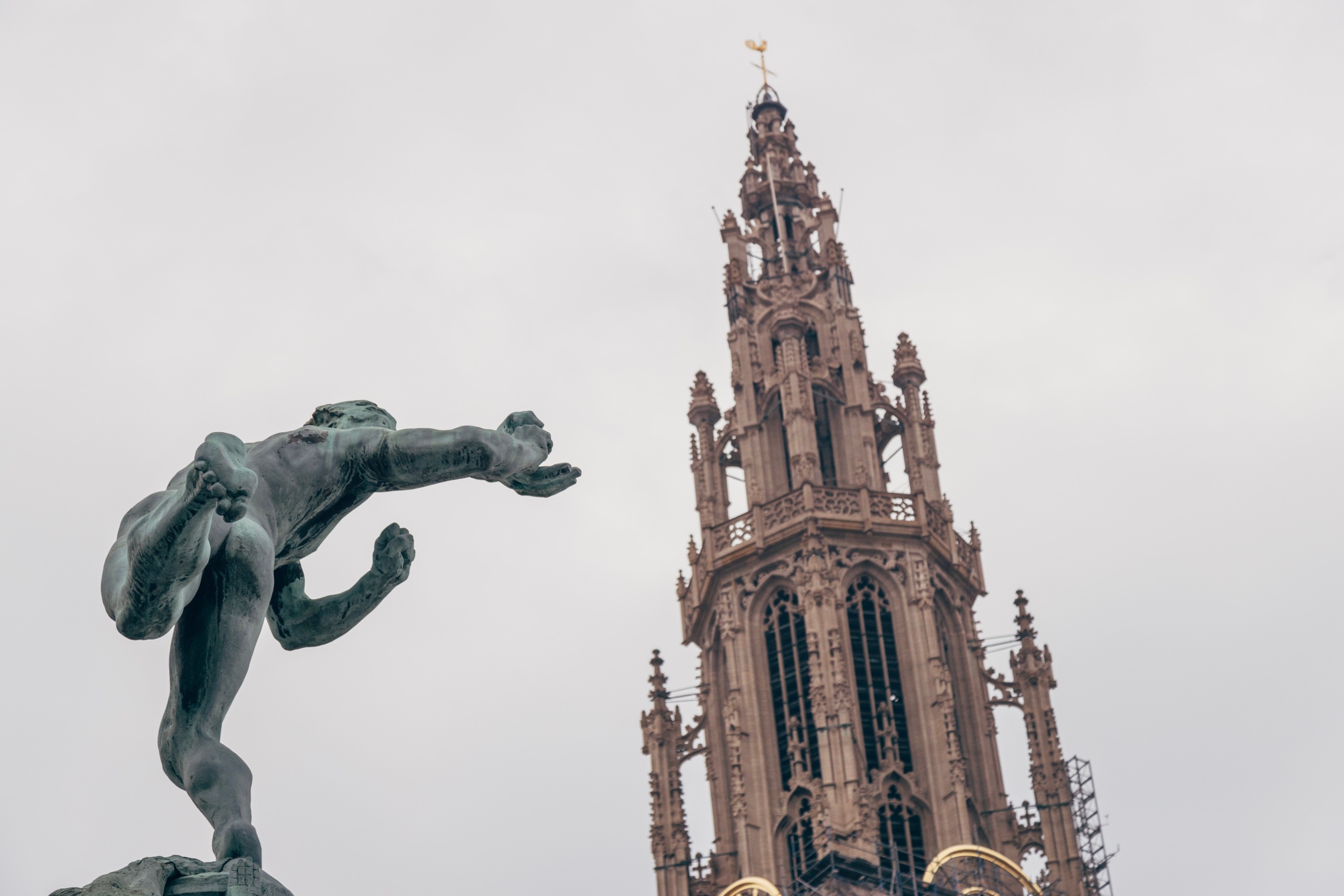 In the forground a rear shot of the Brado Fountain with the the spire of the Cathedral of Our Lady in the background — Main Square, Antwerp City, Belgium