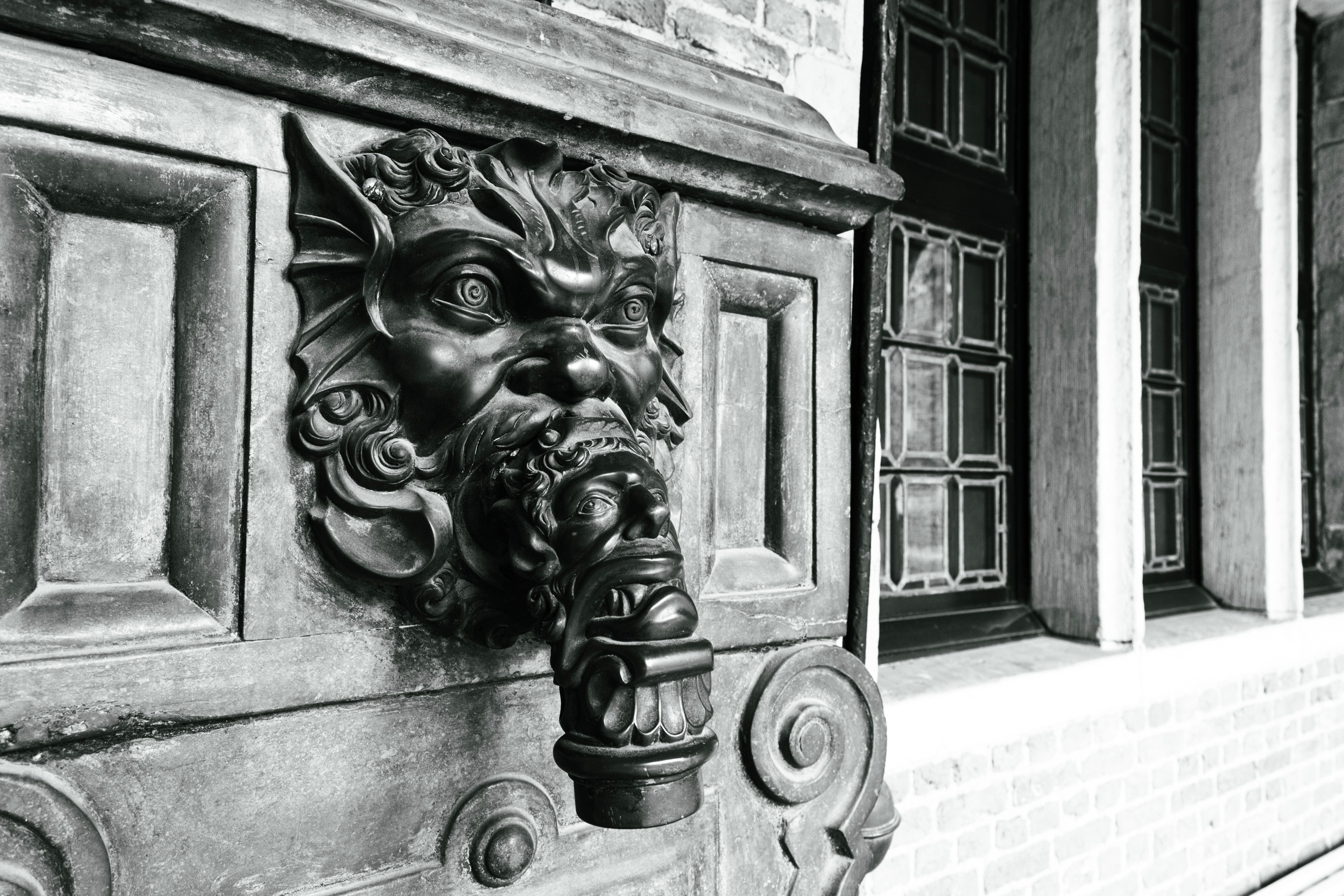A ornate  17th century hand water pump outlet, which is designed to look like a human-link fantasy creature. The outlet pipe is also decorated in an additional face  — Museum Plantin-Moretus, Antwerp, Belgium 