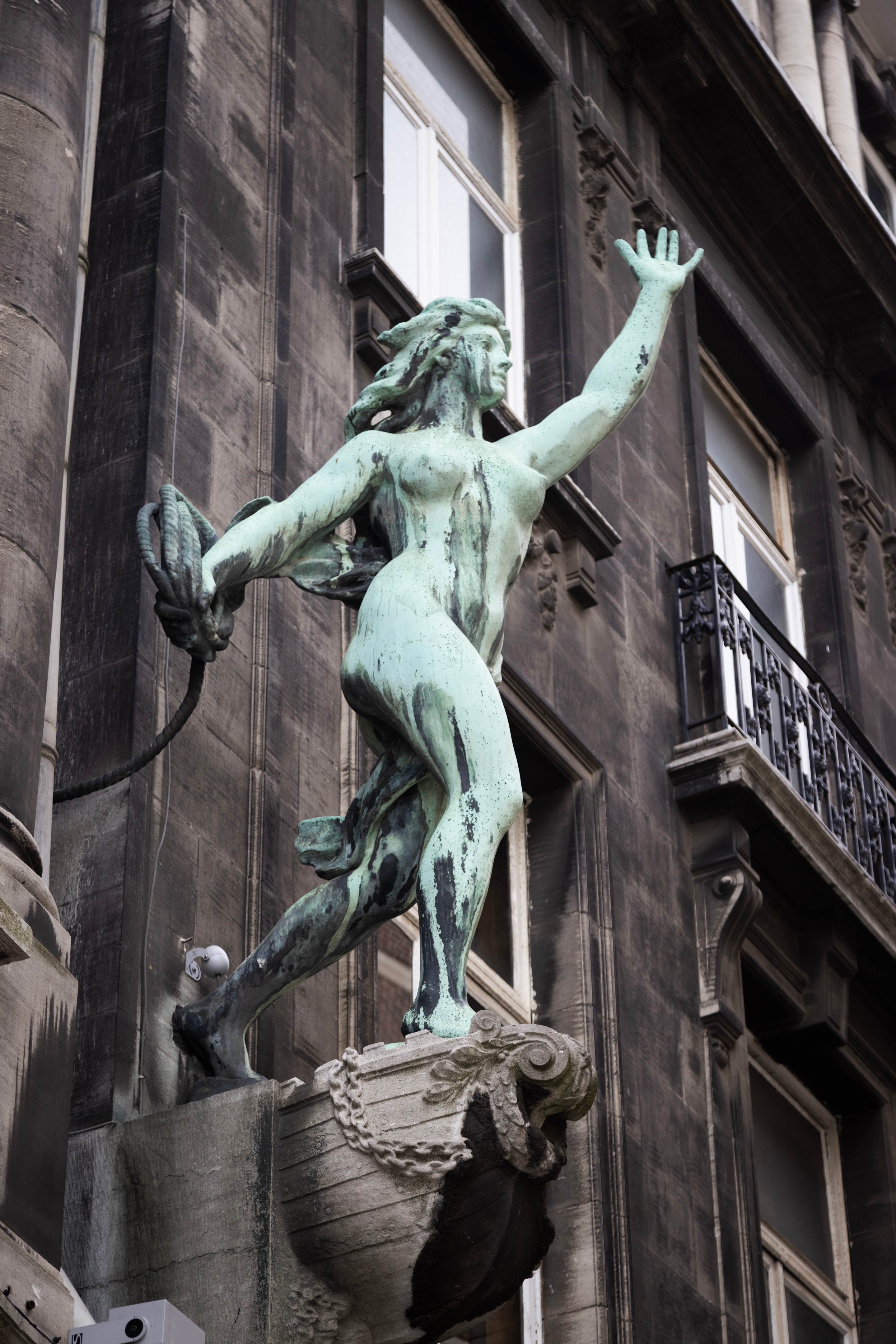 A close-up of a bronze nude female statue throwing rope on a street off the Main Square — Antwerp City, Belgium