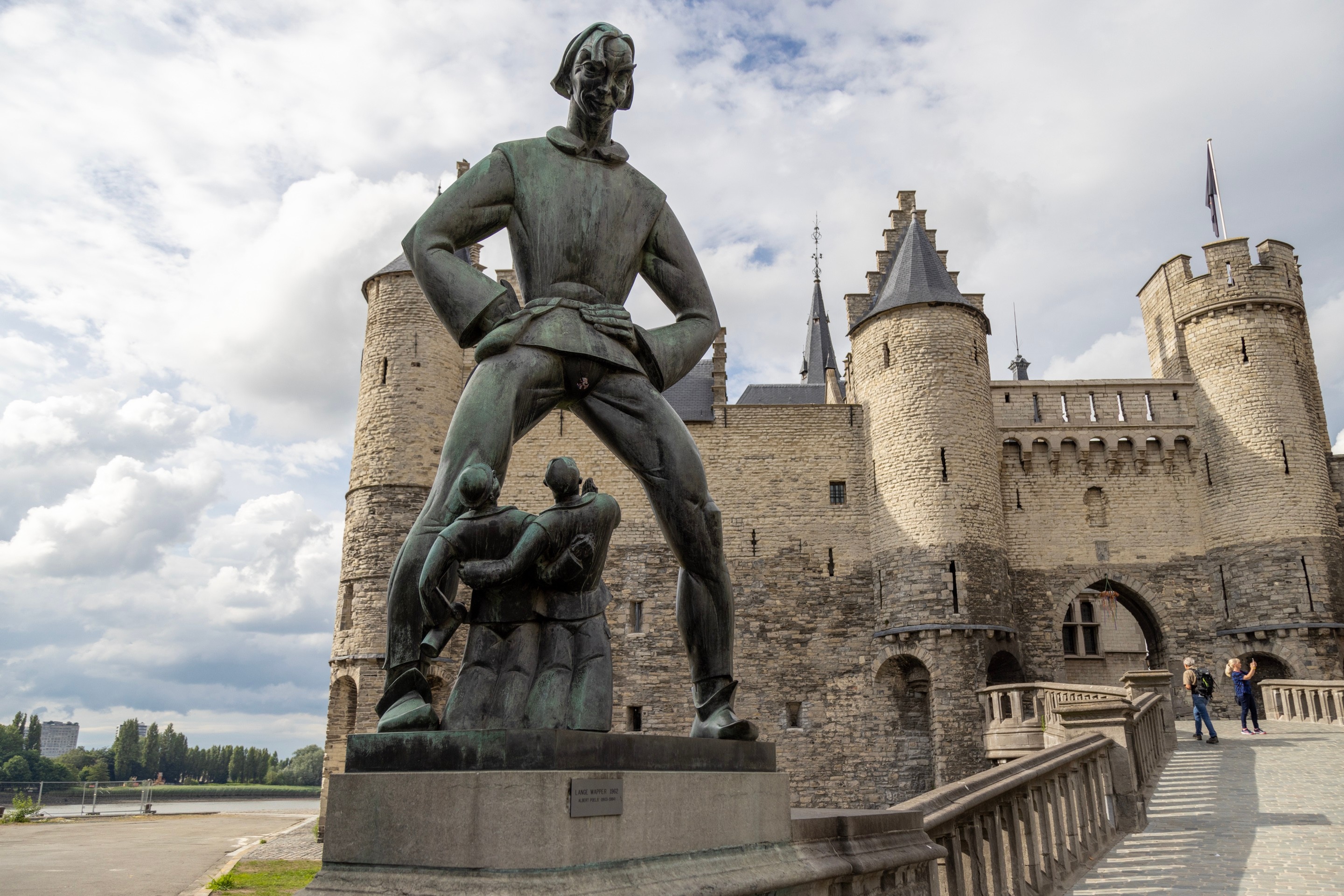 In the foreground the Lange Wapper statue leads the eye up the path and bridge to the Het Steen fort building — Antwerp City, Belgium