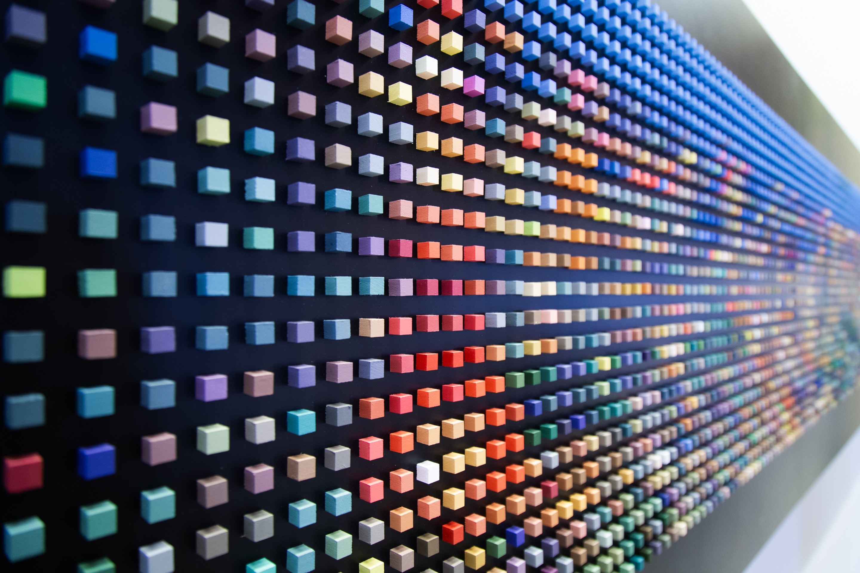 Small coloured cubes act as 'pixels' on a black background. Each pixel a point of light building a picture of the Tokyo cityscape at night. The perpective of the shot is strong. Tokyo, Japan.