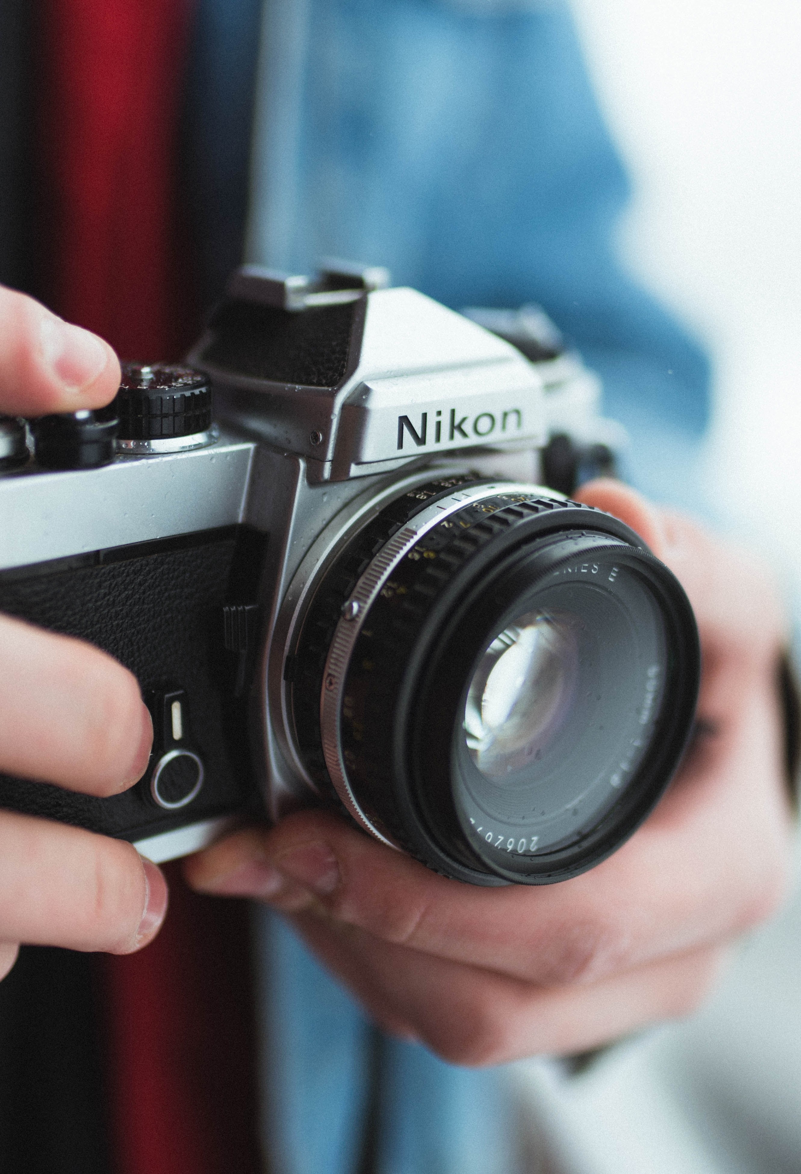 A photograph of a man holding a Nikon FM SLR film camera